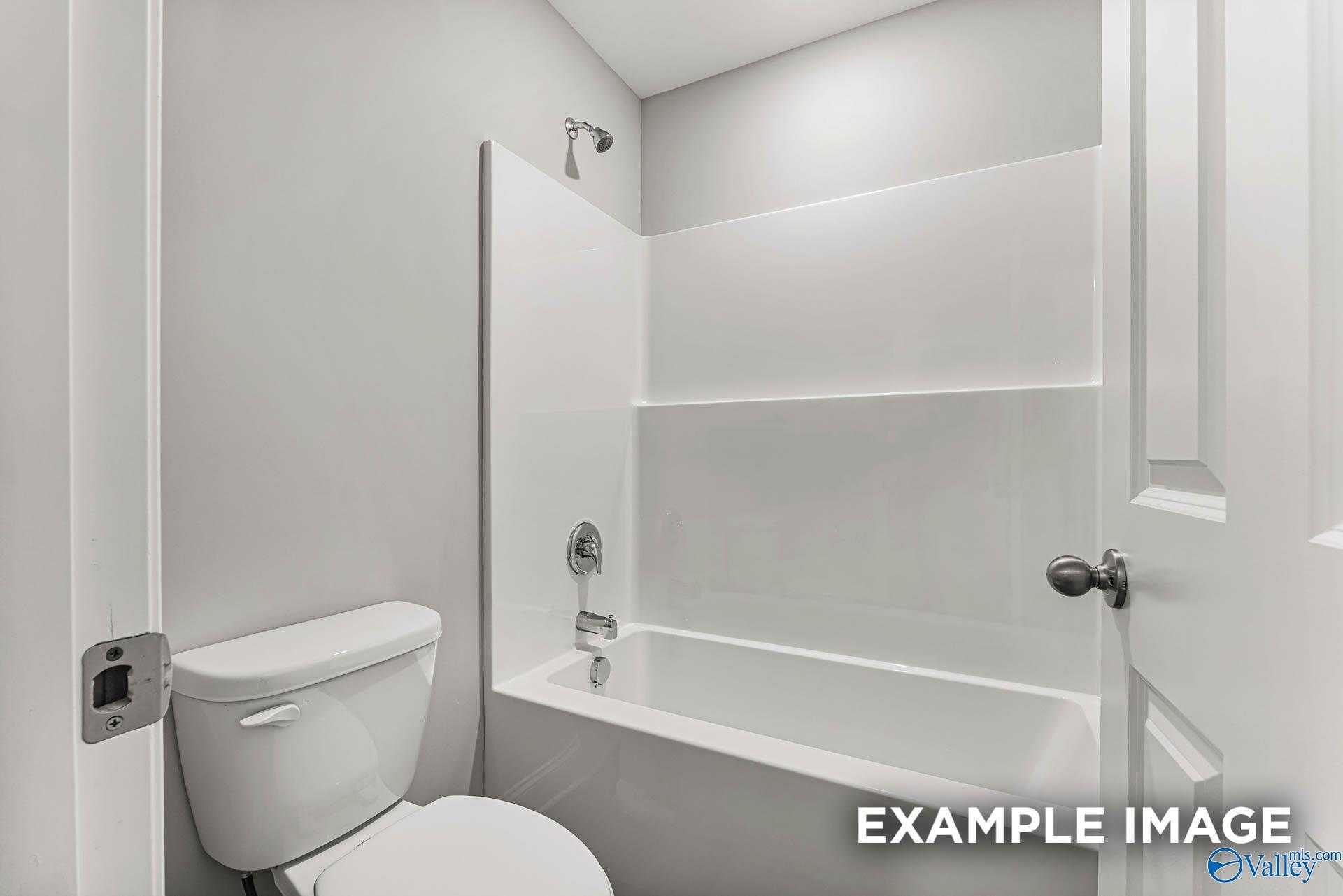 Modern bathroom featuring white bathtub-shower combo and toilet in Davidson Homes The Chelsea A, Athens, Alabama