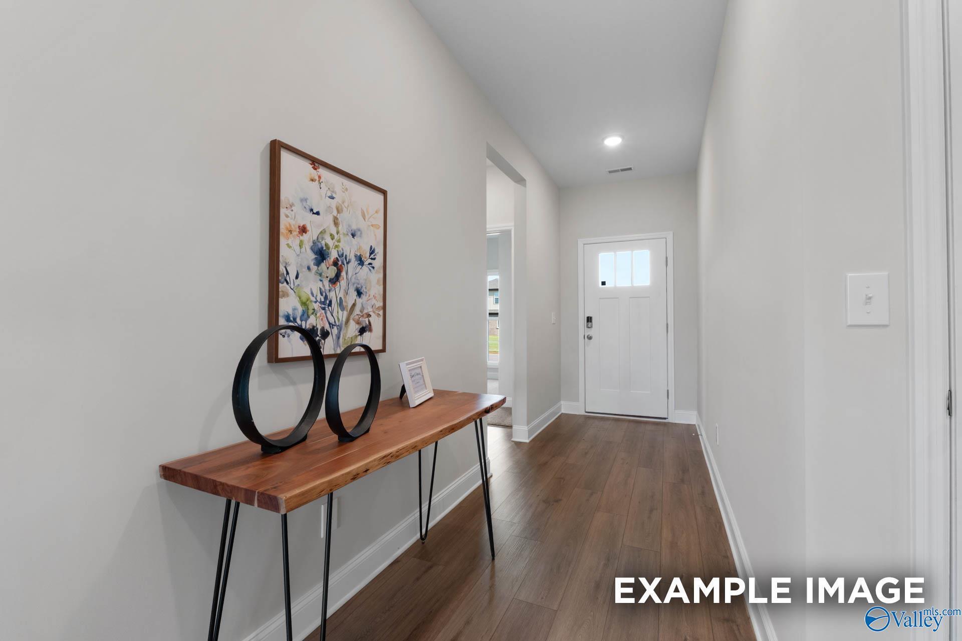 Welcoming foyer with wood-look flooring and console table in The Franklin C floor plan at Heritage Lakes, New Market, AL.