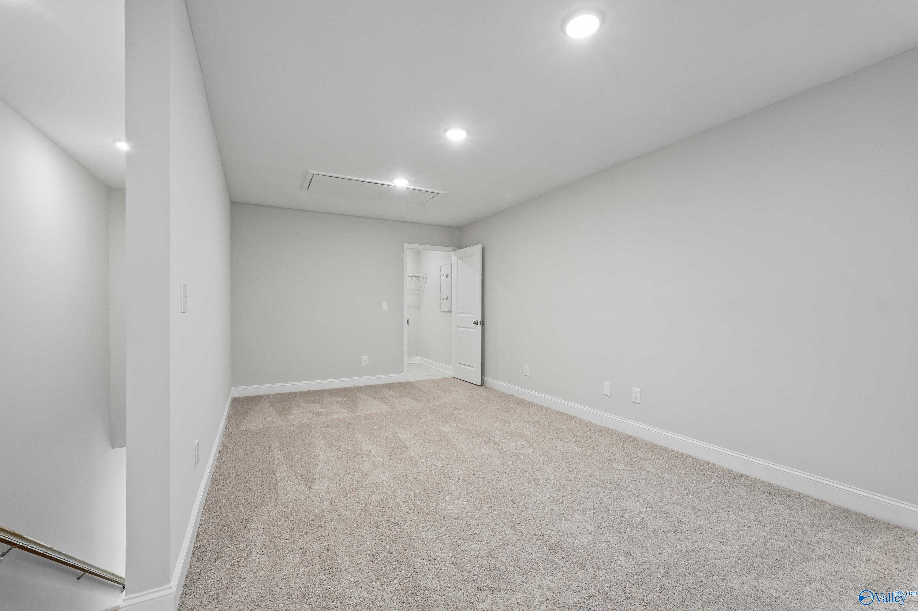 Bright secondary bedroom with attached bath, light gray walls, beige carpet, recessed lights in Davidson Homes The Camden, Huntsville AL