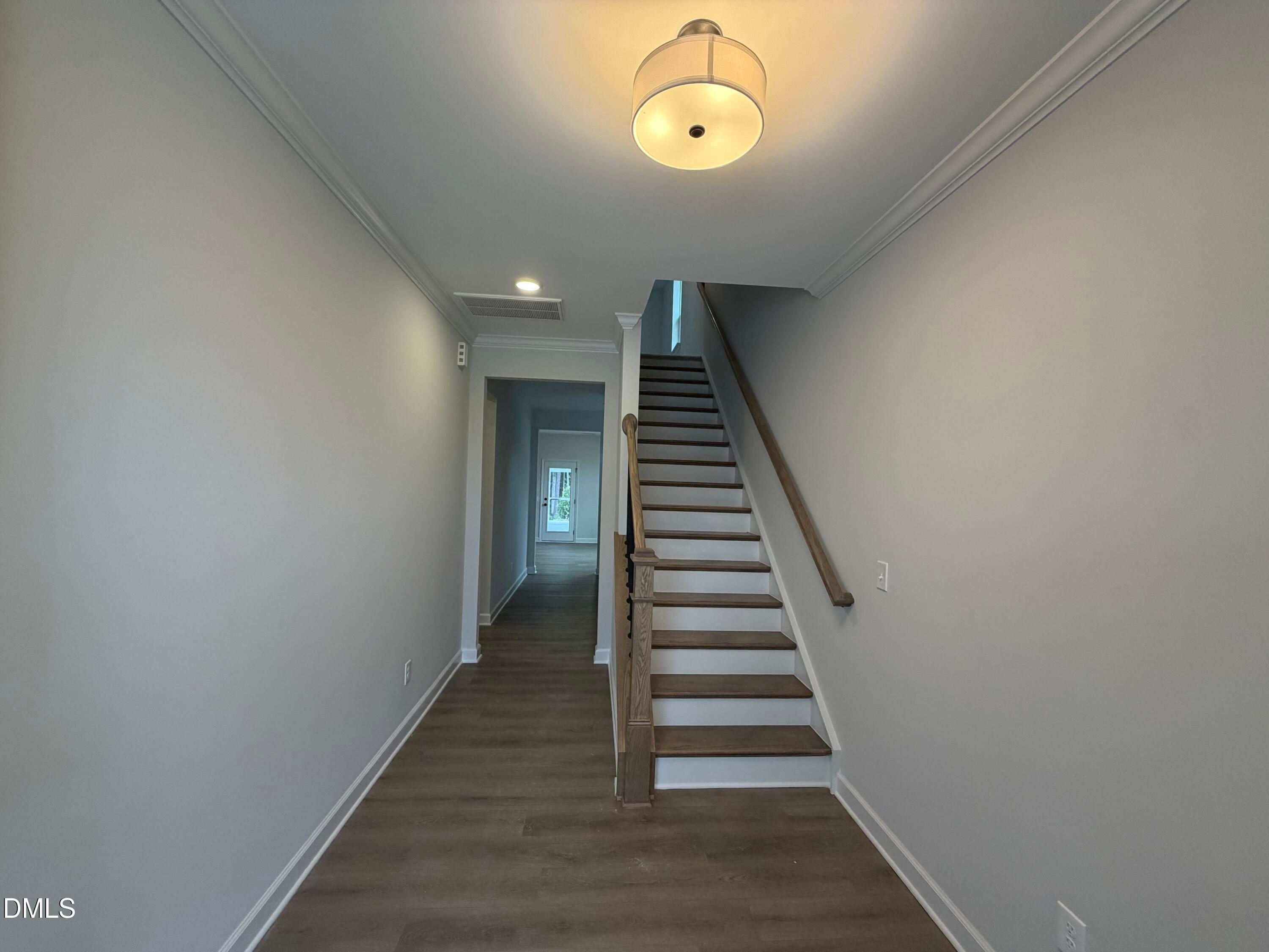 Foyer with wooden staircase and hardwood floors in Davidson Homes The Preston C 2-story home in Wendell Ridge, North Carolina