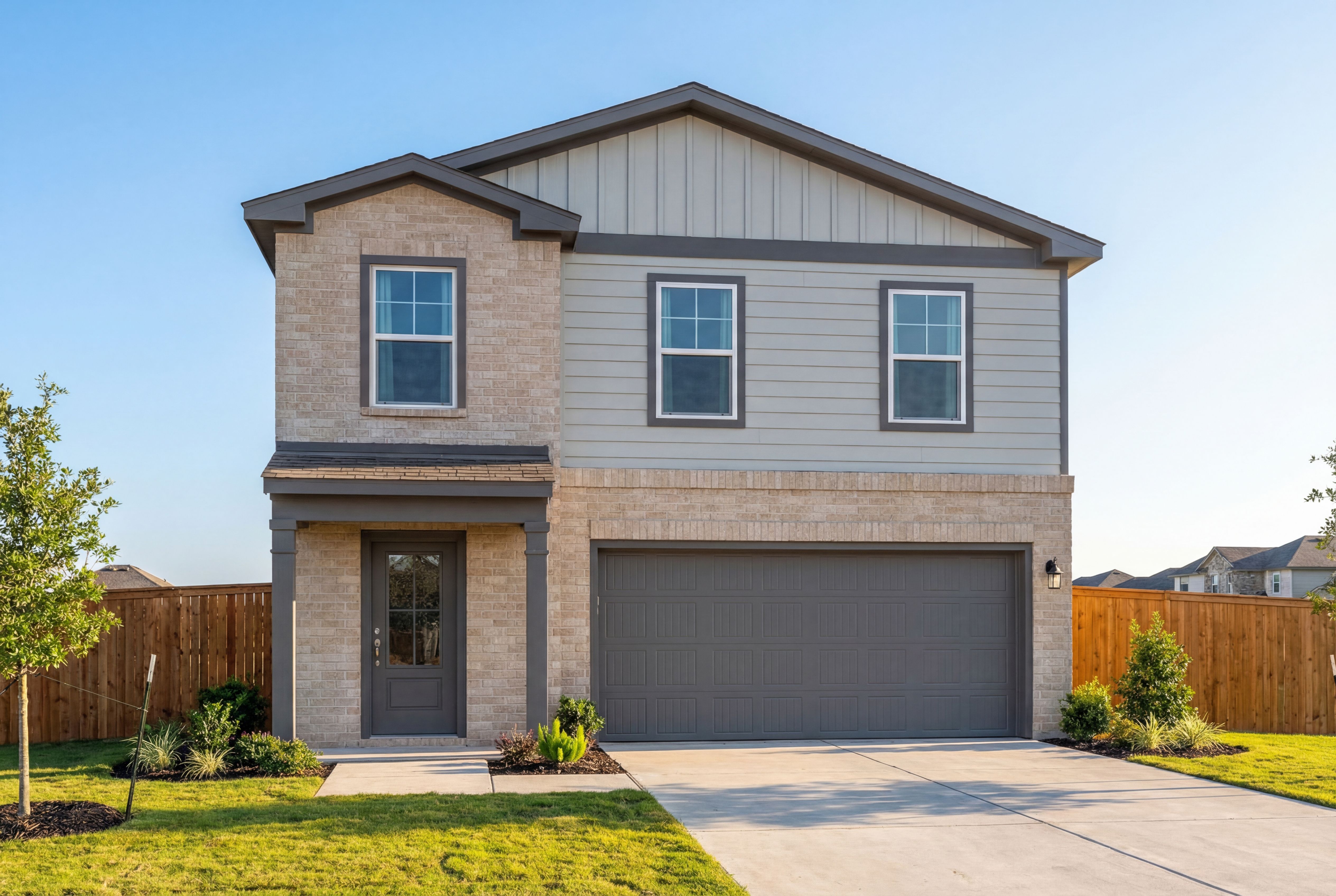Two-story Trinity D home elevation by Davidson Homes in San Antonio featuring beige brick, gray siding, covered porch, and 2-car garage