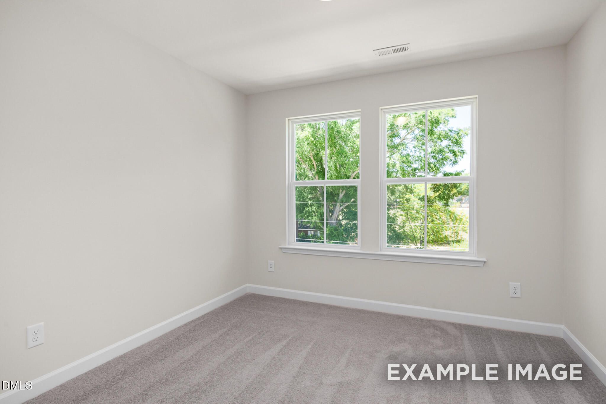 Bright, carpeted bedroom with large windows in The Mitchell Interior floor plan at Camden Park, Knightdale, North Carolina.