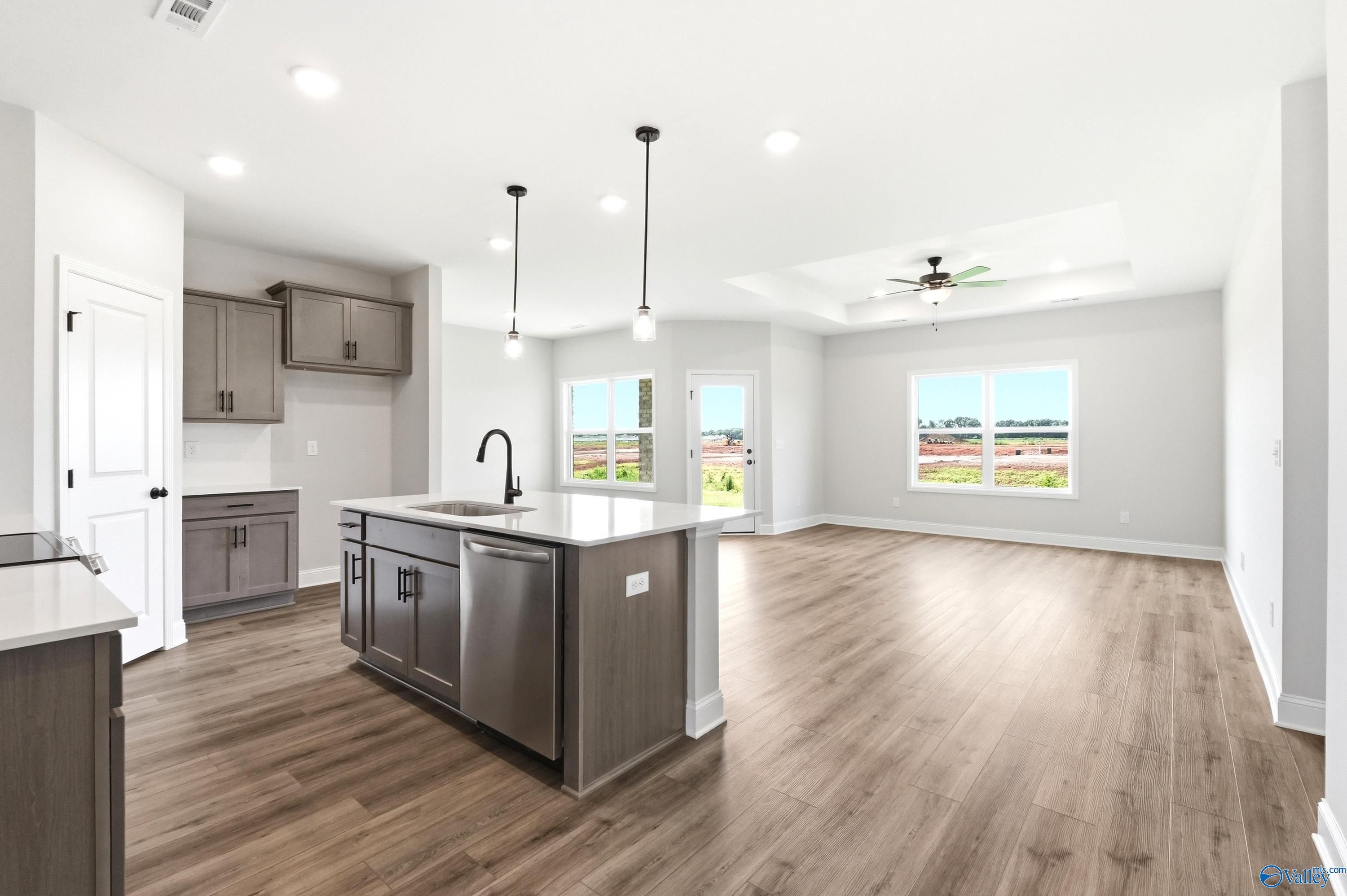 Open-concept kitchen and living area with island in The Daphne floor plan by Davidson Homes in Clearview, Hazel Green, AL.