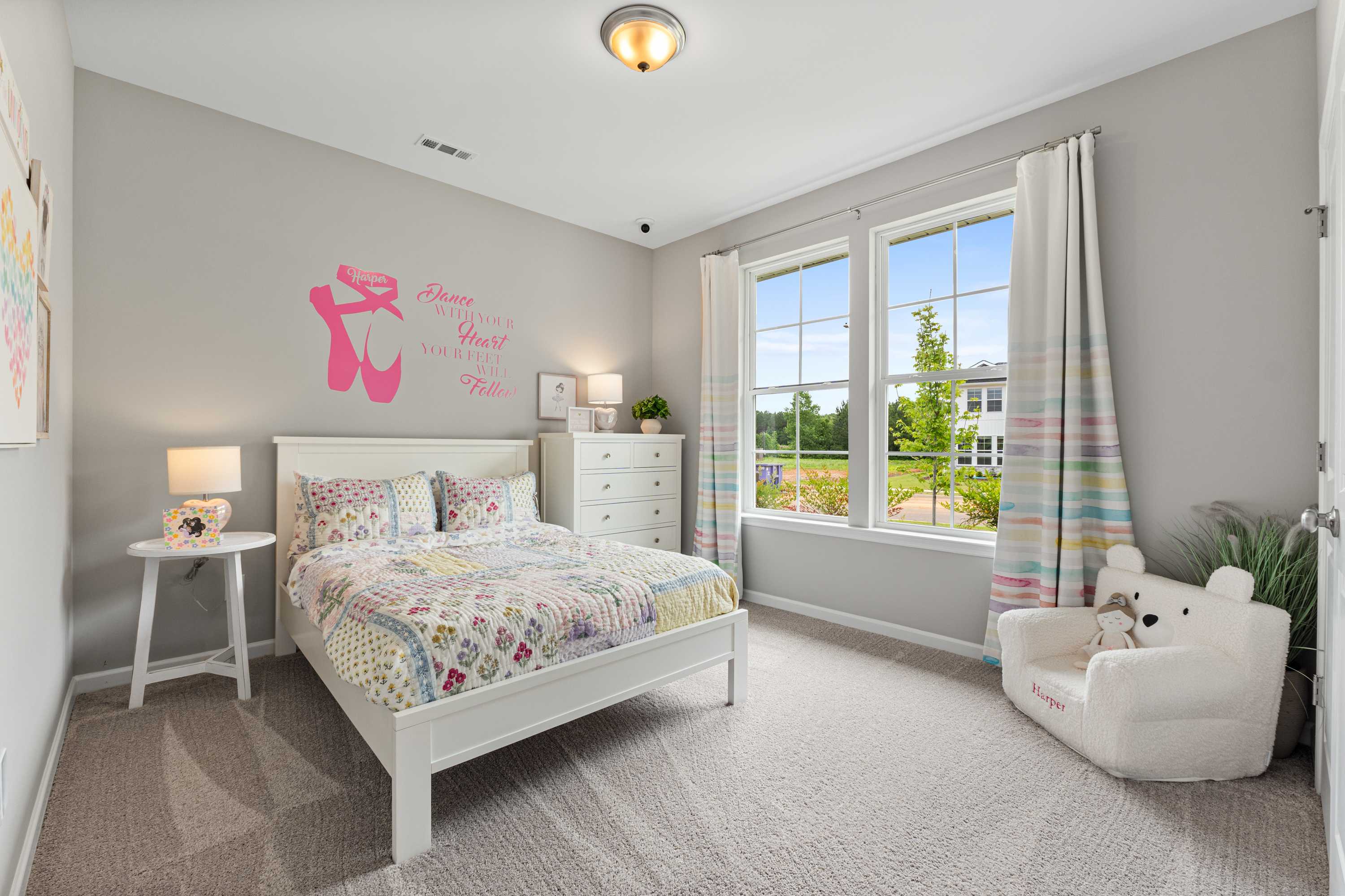 Charming ballet-themed girl's bedroom at Forest Glen in Hazel Green Alabama with colorful quilt bed and scenic tree view