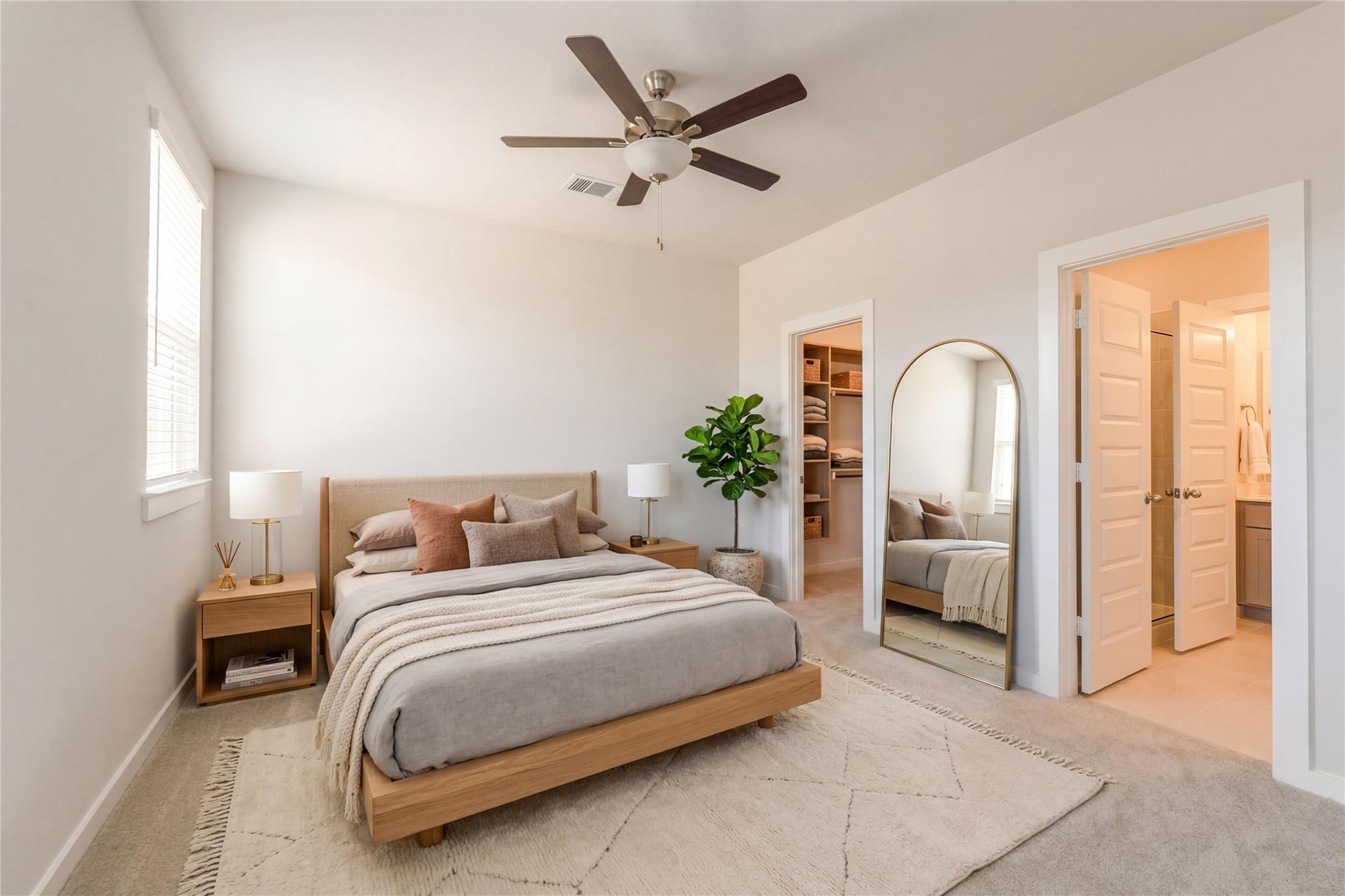 Modern bedroom with platform bed, arched mirror, potted plant, and en-suite bath in Davidson Homes The Colorado F, Cleveland, TX