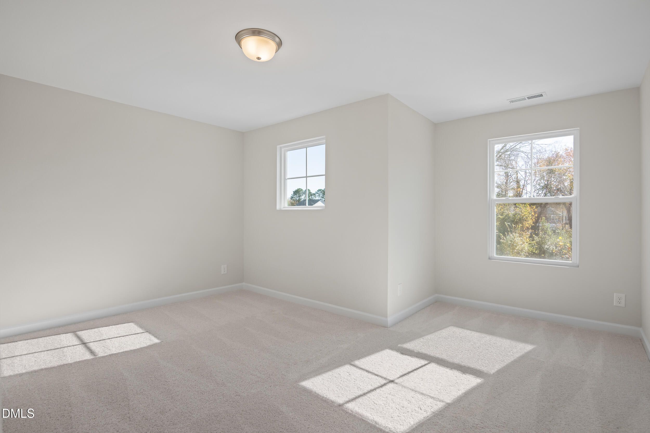 Bright secondary bedroom with beige carpet, light gray walls, and sunny windows in Davidson Homes The Preston C, Lillington, NC