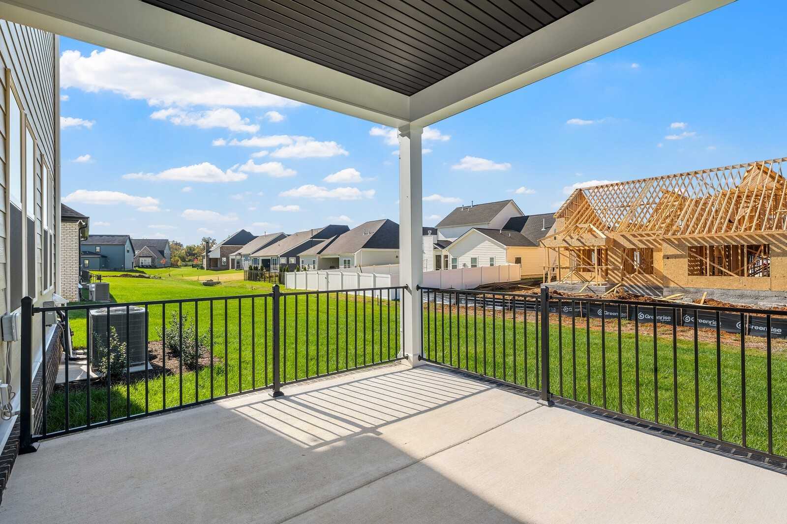 Covered back patio with black ceiling overlooking fenced green backyard and neighboring homes in Shelton Square, Murfreesboro, Tennessee