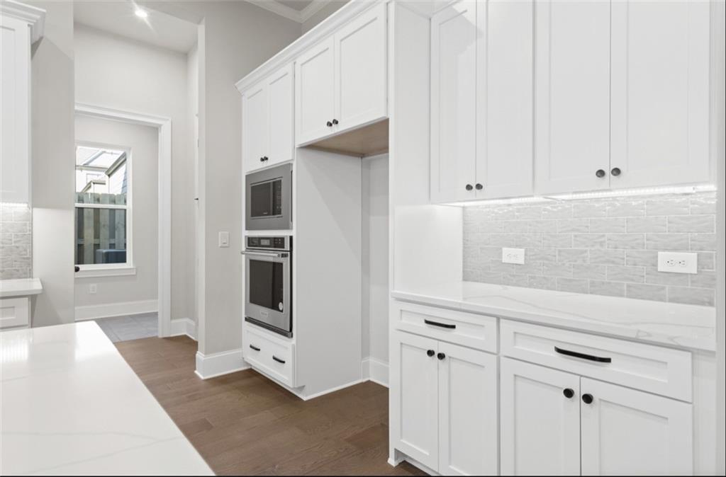 Modern white shaker kitchen with quartz counters, double ovens, subway backsplash in Davidson Homes Seaside A, Woodstock GA