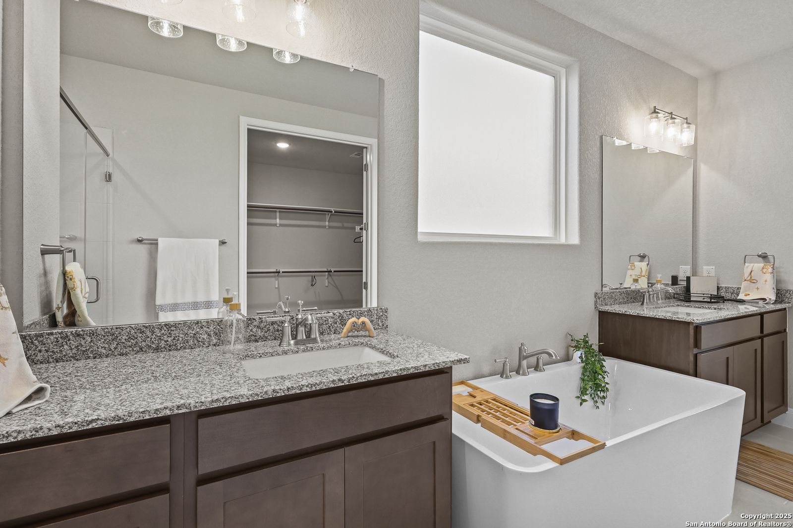 Elegant master bathroom with double granite vanity, freestanding tub, walk-in shower in Davidson Homes The Jennings G, Castroville, Texas