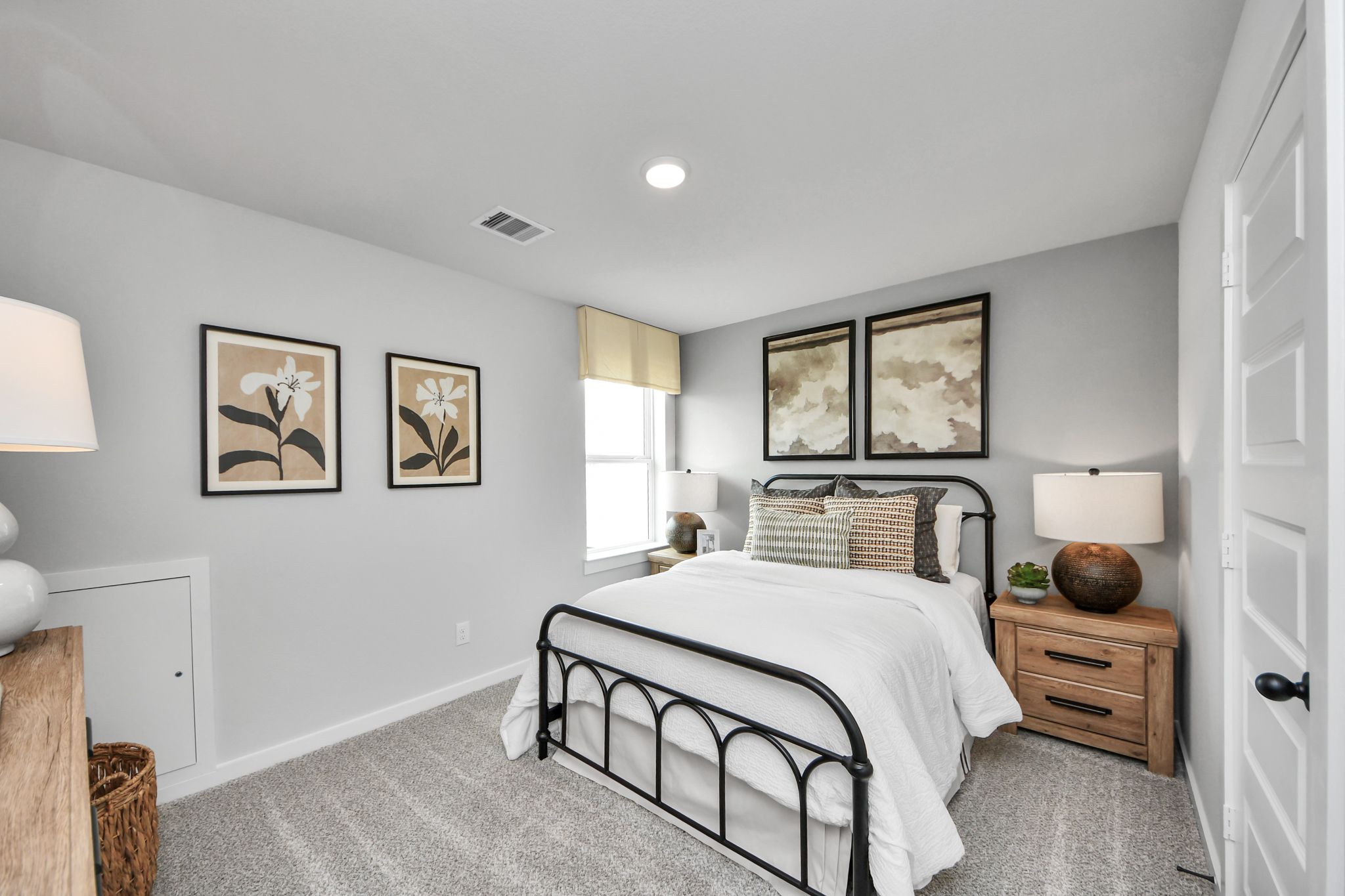 Cozy bedroom with black iron bed frame and neutral decor at Robins Landing in Houston, TX by Davidson Homes