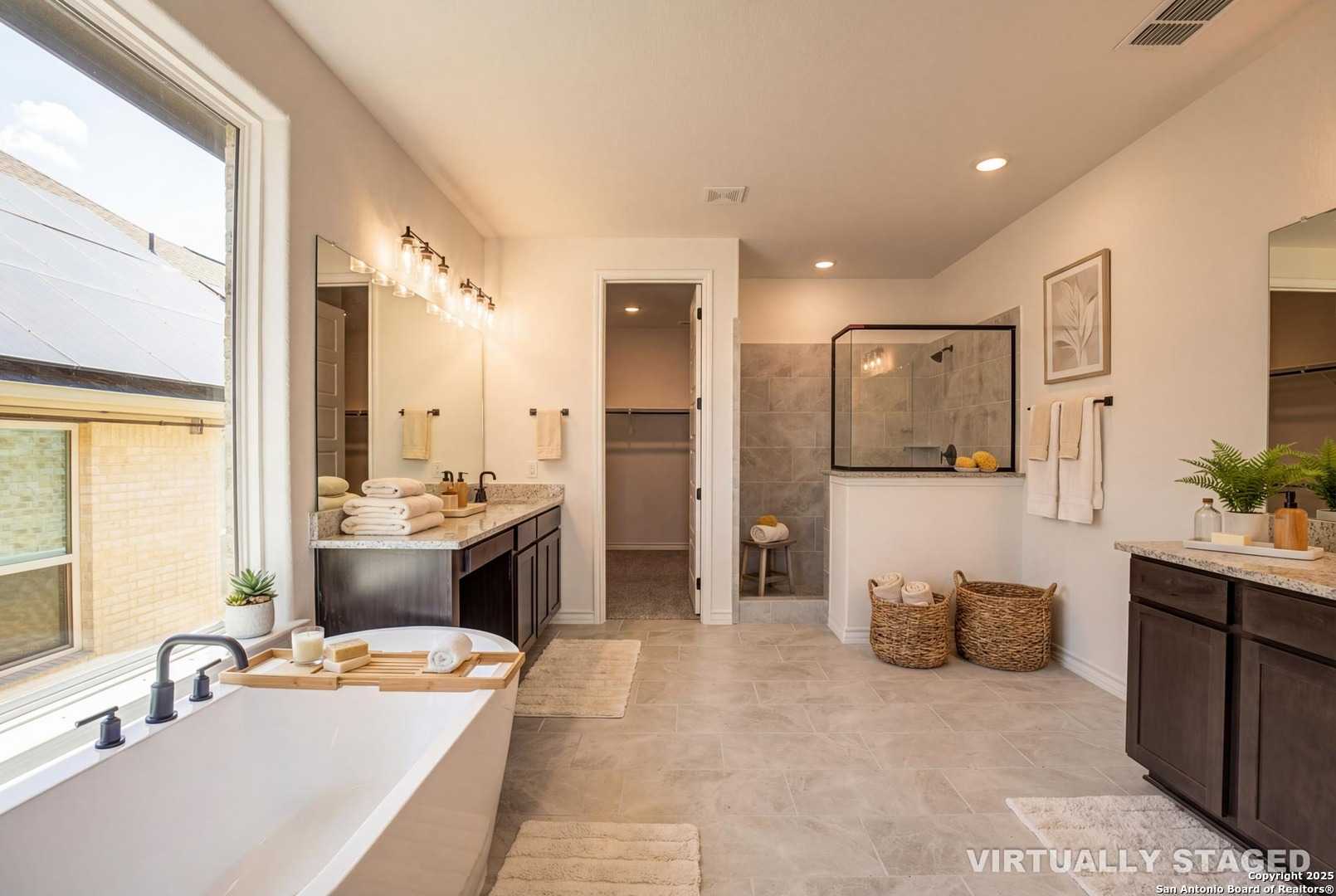 Elegant master bathroom with freestanding tub, dual vanities, walk-in shower in Davidson Homes The Garner B, Castroville, Texas