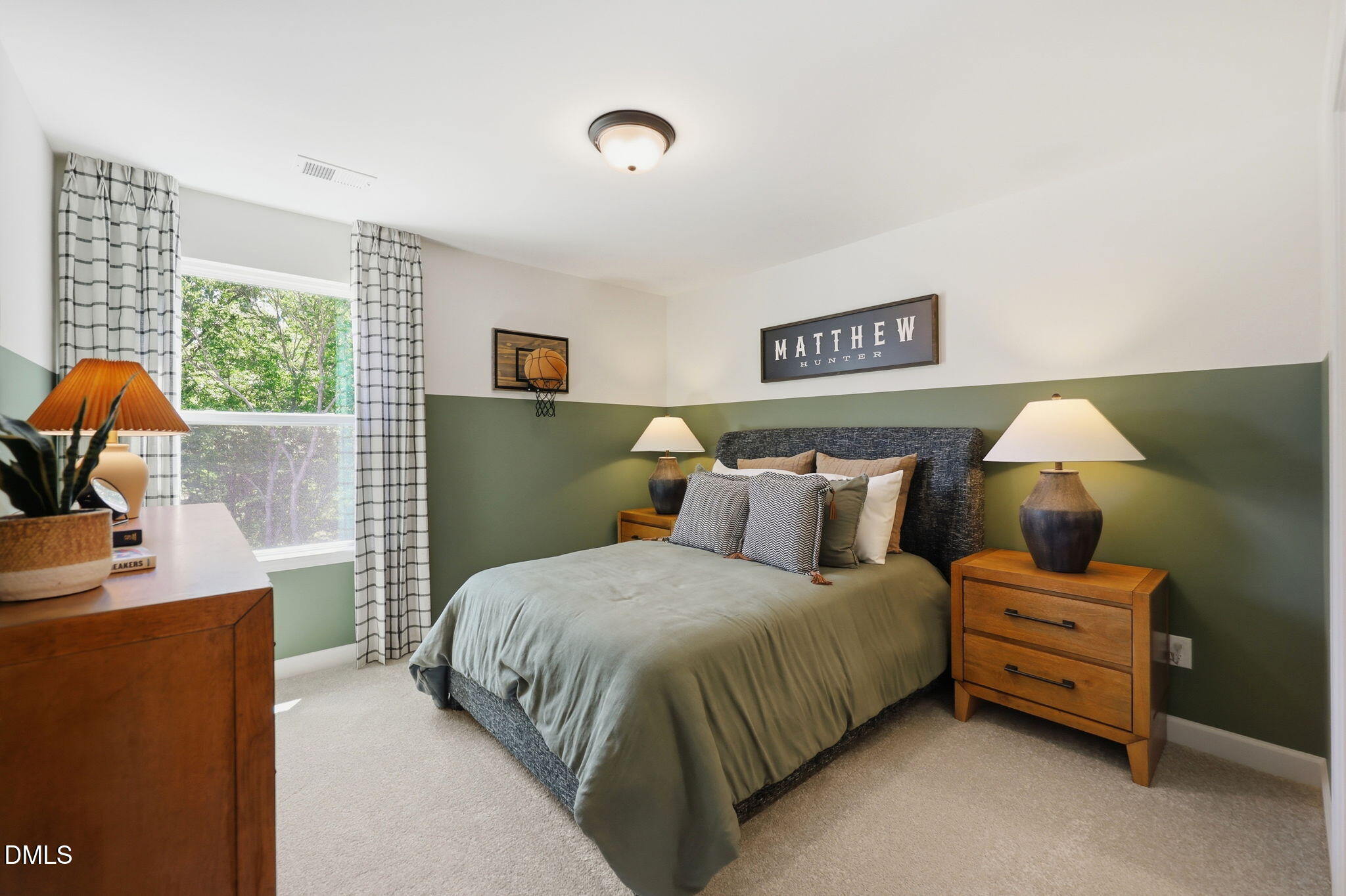 Cozy bedroom with sage green walls and wooden furniture in The Aspen B floor plan at Wendell Ridge in Wendell, NC.
