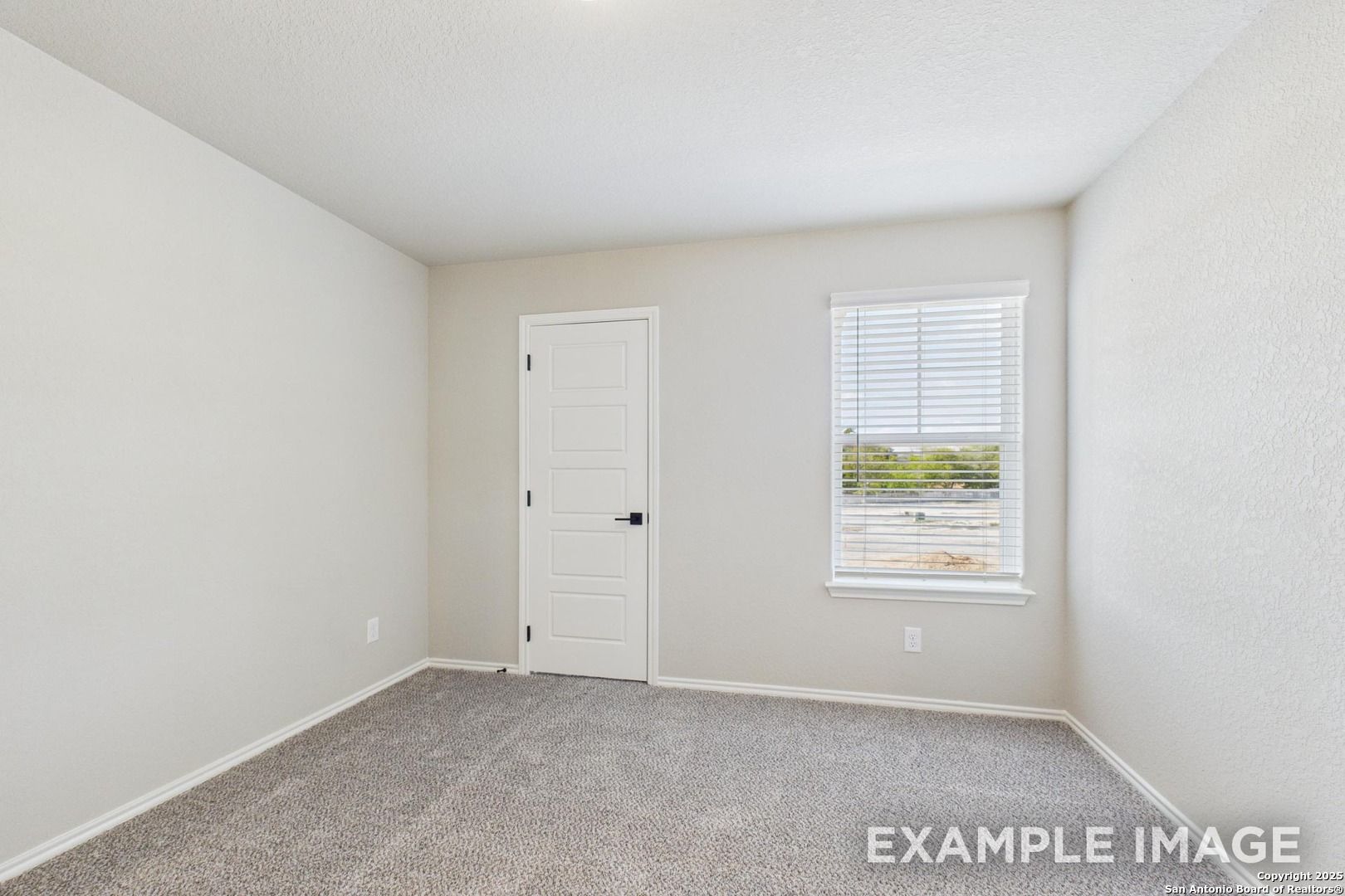 Bright secondary bedroom with beige walls, white door, carpet floor, and window blinds in Davidson Homes The Charlotte A, San Antonio