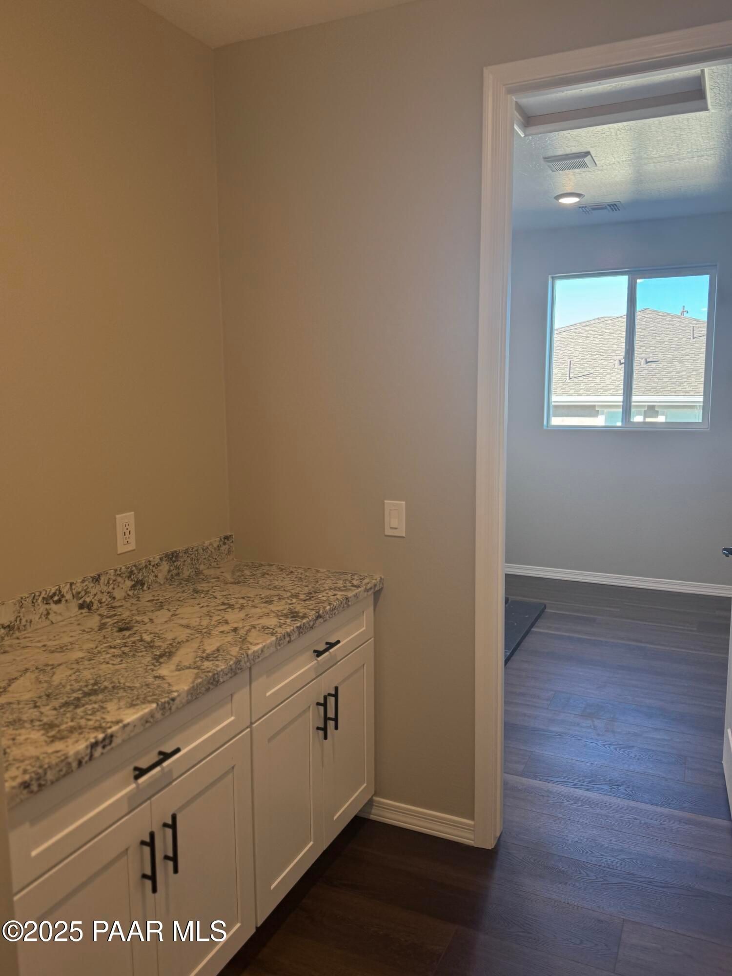 Modern quartz countertop with white shaker cabinets in open kitchen of 3-bedroom Davidson Homes The Monarch E, Prescott AZ