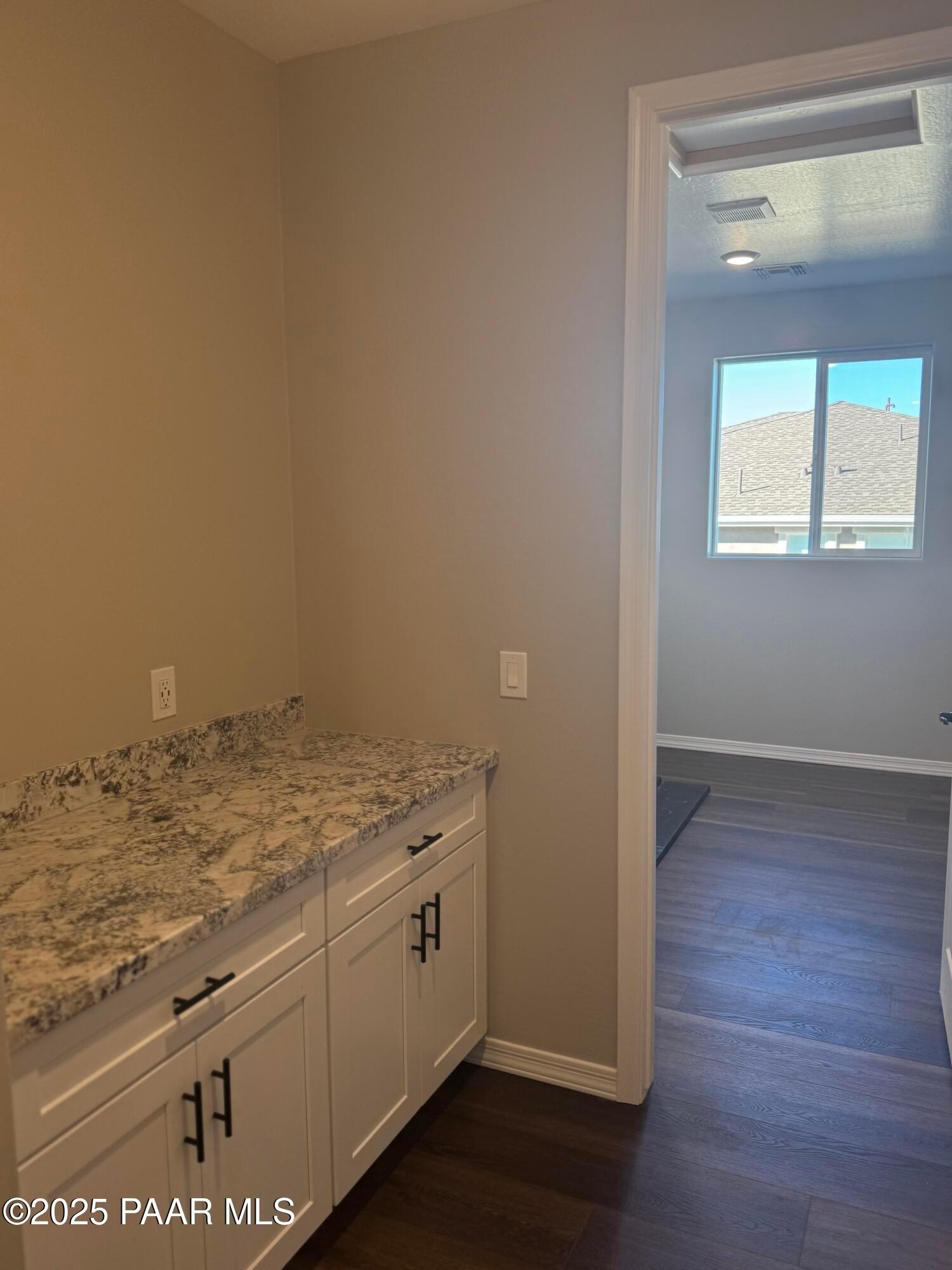 Modern quartz countertop with white shaker cabinets in open kitchen of 3-bedroom Davidson Homes The Monarch E, Prescott AZ