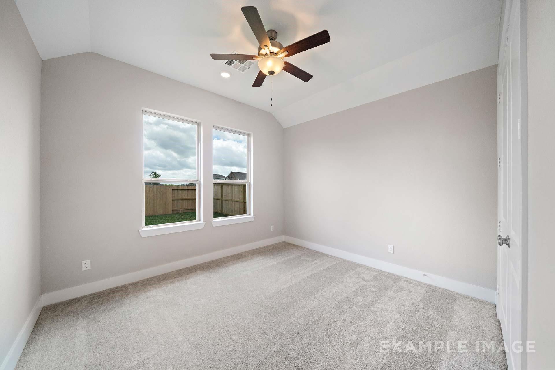 Bright bedroom with vaulted ceiling, ceiling fan, and carpet in Davidson Homes The Elizabeth A, Lago Mar, Texas City, Texas