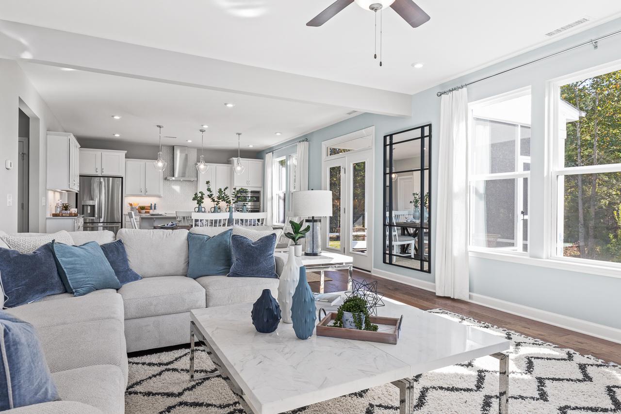 Open-concept living room and kitchen in The Hemlock by Davidson Homes featuring a marble coffee table and modern decor.
