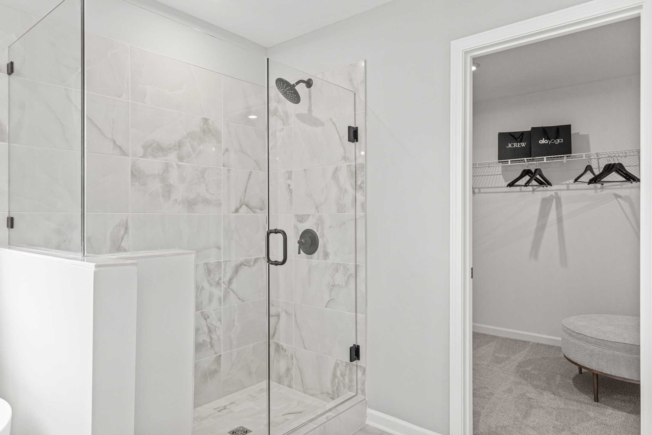 Spacious master bathroom in The Hickory A with frameless glass shower, subway tile walls, and walk-in closet