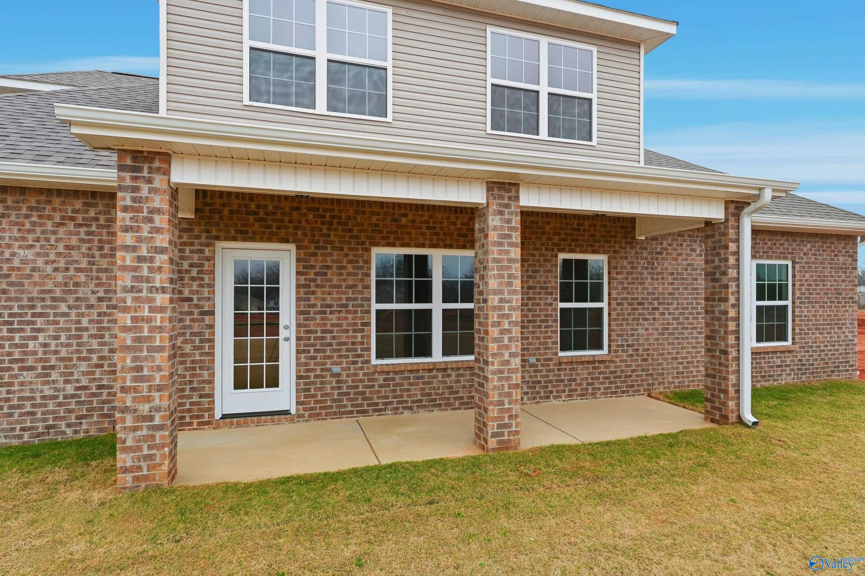 Brick ranch home exterior with covered porch, brick columns, and large windows in River Road Estates, Decatur, Alabama