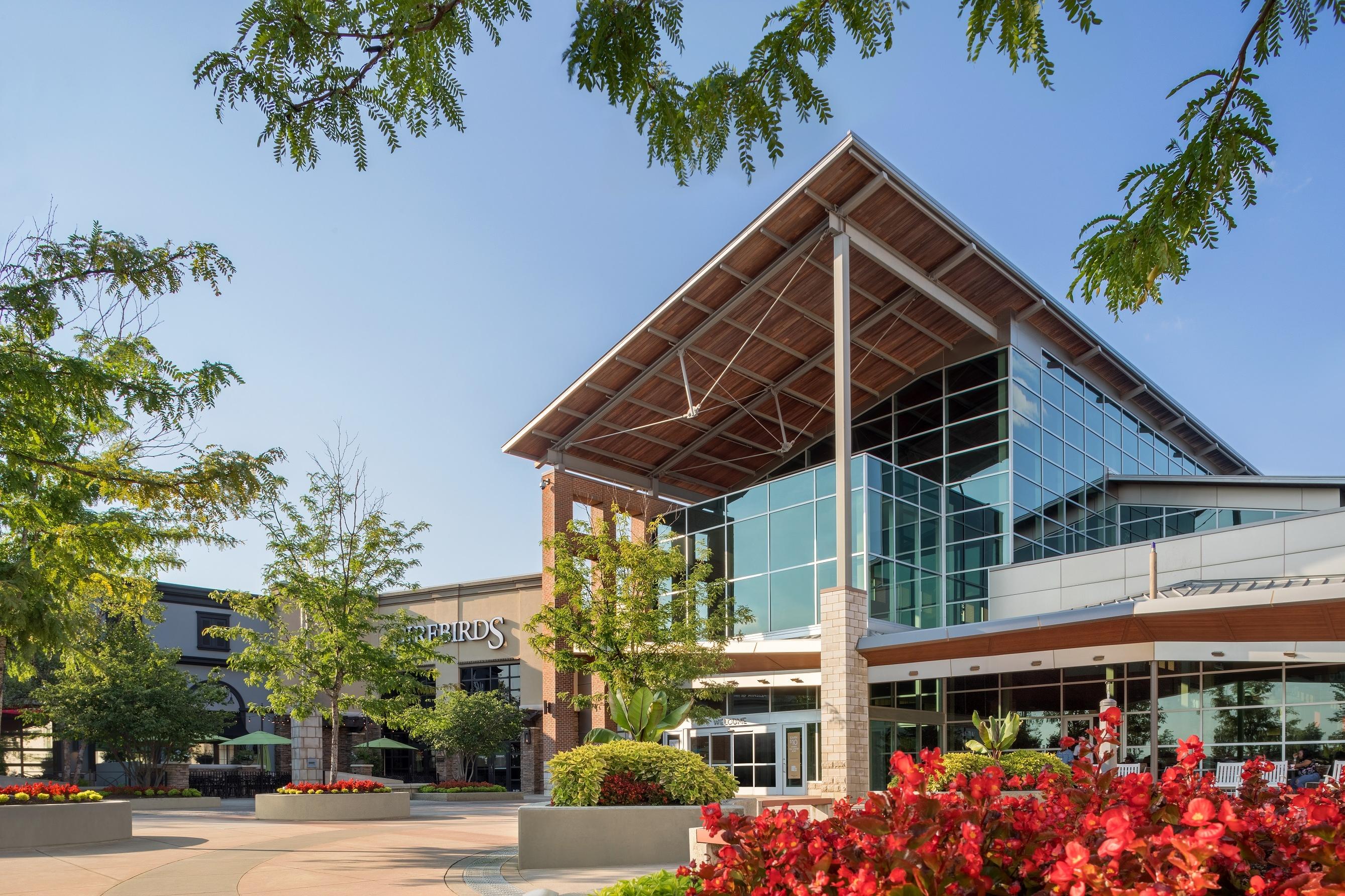 Modern shopping center near Long Creek Townhomes in Charlotte, NC featuring glass architecture and landscaped flower beds.