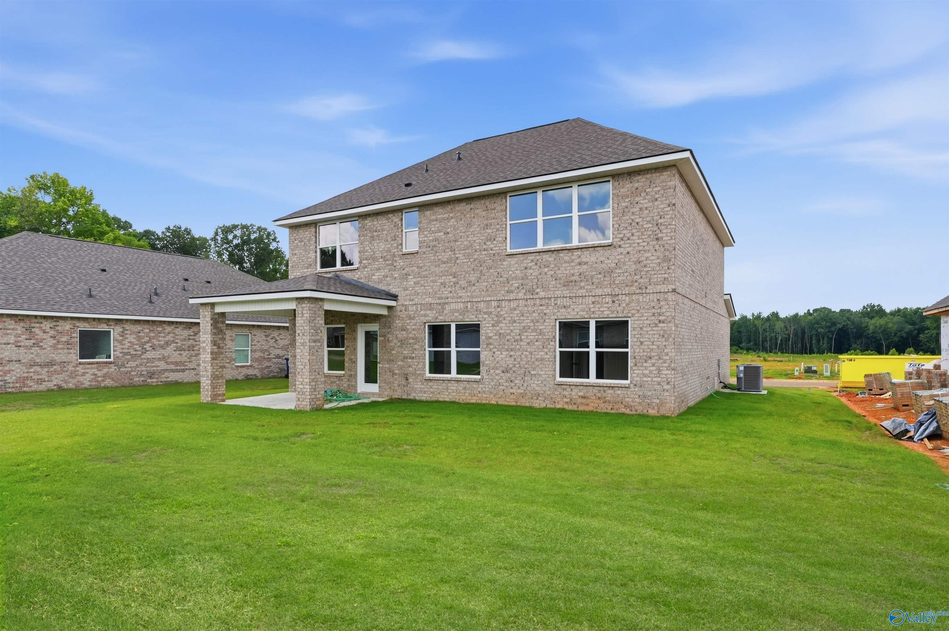 Two-story brick exterior of The Shelby A floor plan with covered back patio in Wood Trail, Toney, Alabama.