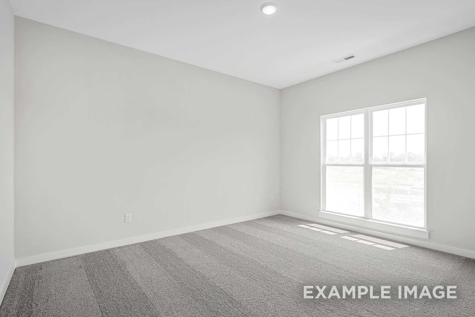 Spacious secondary bedroom in The Hathaway with light gray walls, large window, and neutral carpet flooring