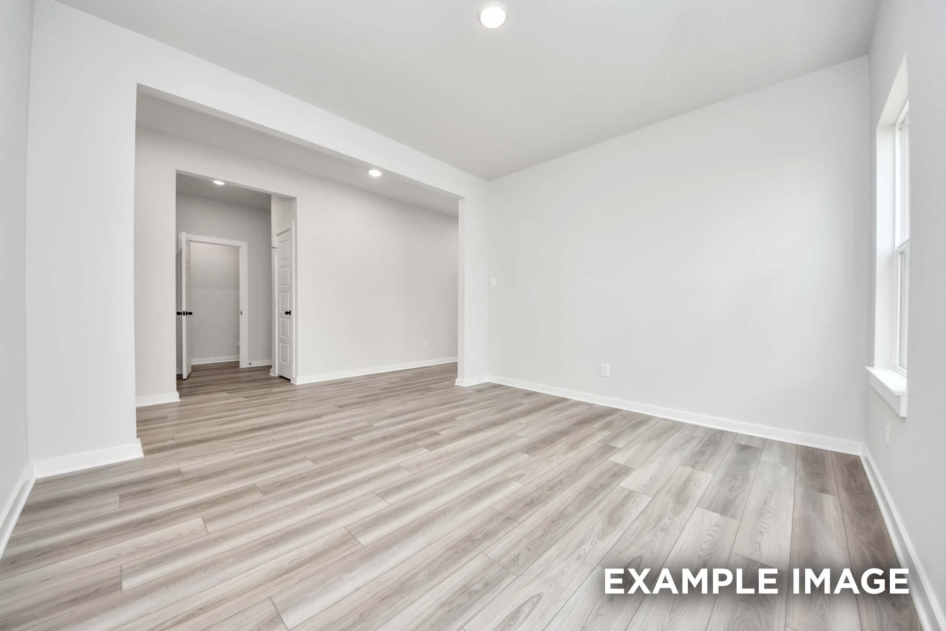 Bright, spacious bedroom in The Sorrento F floor plan featuring modern wood-look flooring and neutral paint in Crosby, TX.