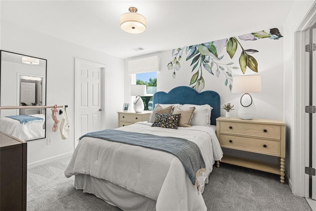 Cozy bedroom with blue tufted headboard bed, botanical leaf wallpaper accent wall, oak nightstands, and carpeted floor in Hoschton, Georgia home