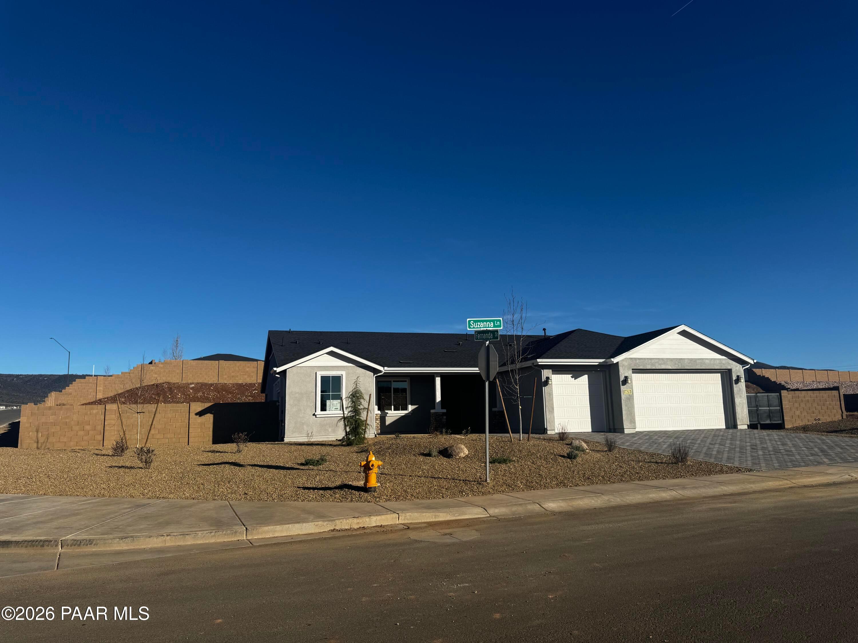 White single-story 3-bedroom home with 3-car garage and desert rock landscaping in Morningstar, Prescott Valley, Arizona