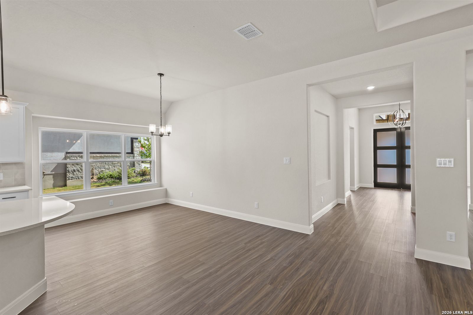 Bright dining area with wood-look flooring in The Summerlin B floor plan by Davidson Homes in Potranco Oaks, Castroville.