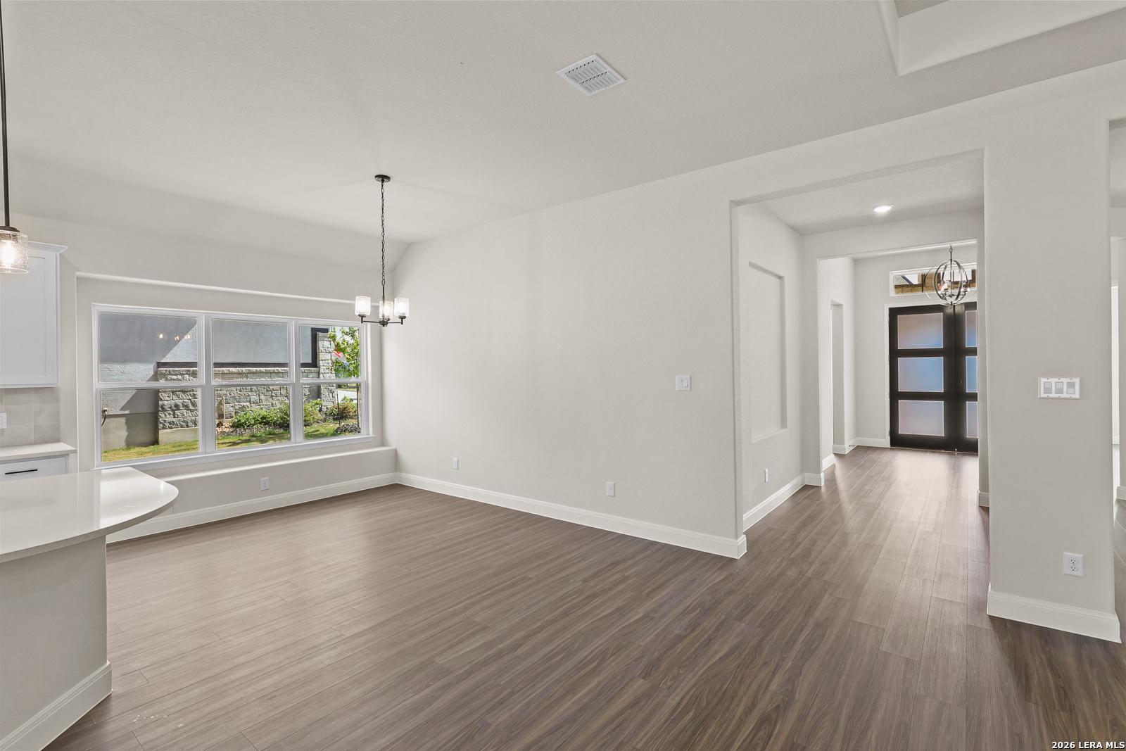 Bright dining area with wood-look flooring in The Summerlin B floor plan by Davidson Homes in Potranco Oaks, Castroville.