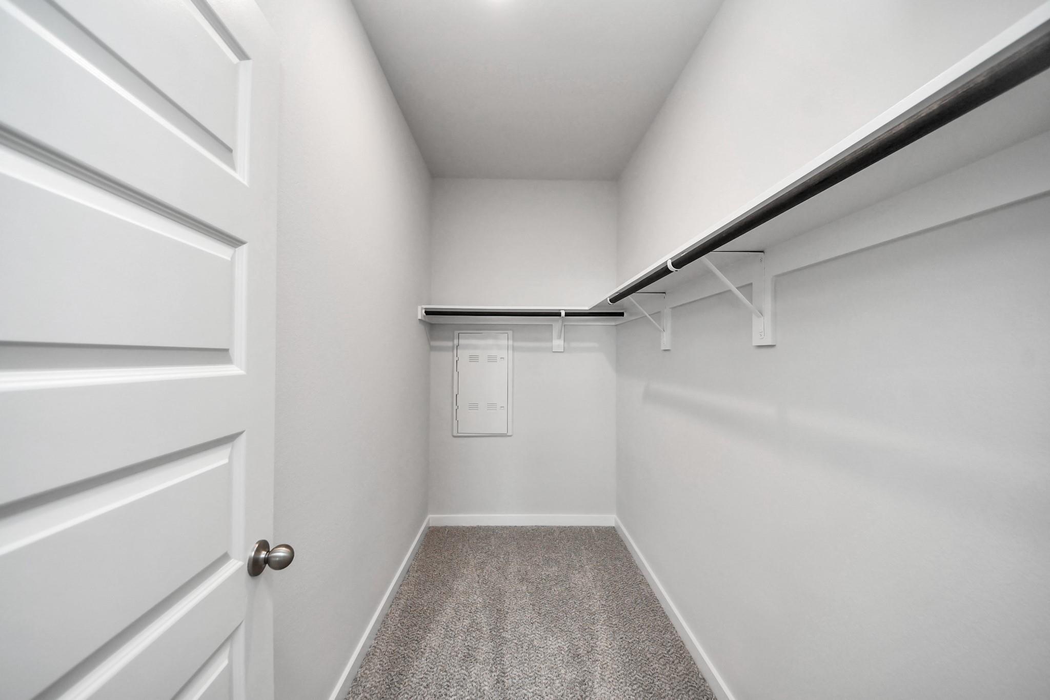 Spacious walk-in closet with hanging rods and shelving in Davidson Homes The Frio F, Robins Landing, Houston, Texas