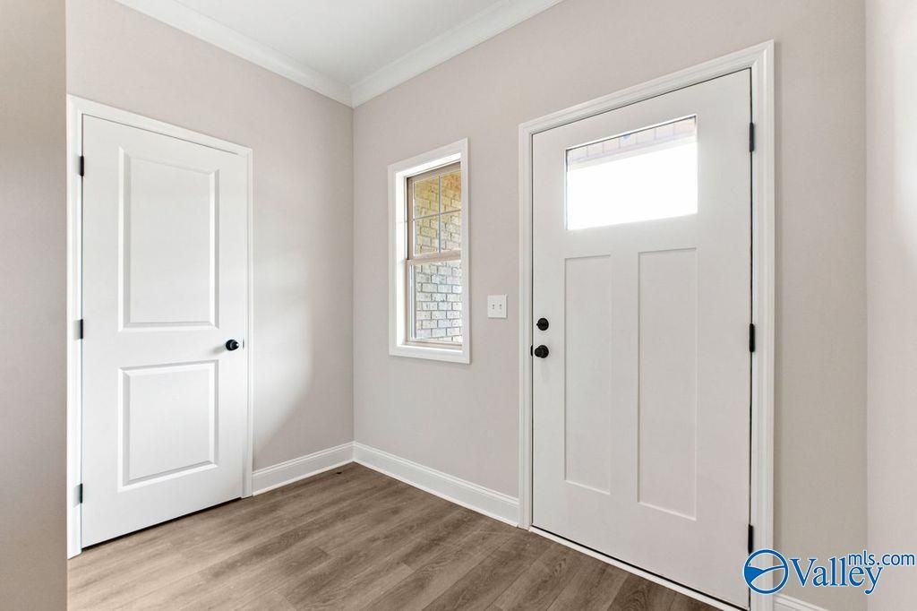 Bright entryway with modern white door and wood-style flooring in The Camilla B floor plan at The Retreat at Cain Park.