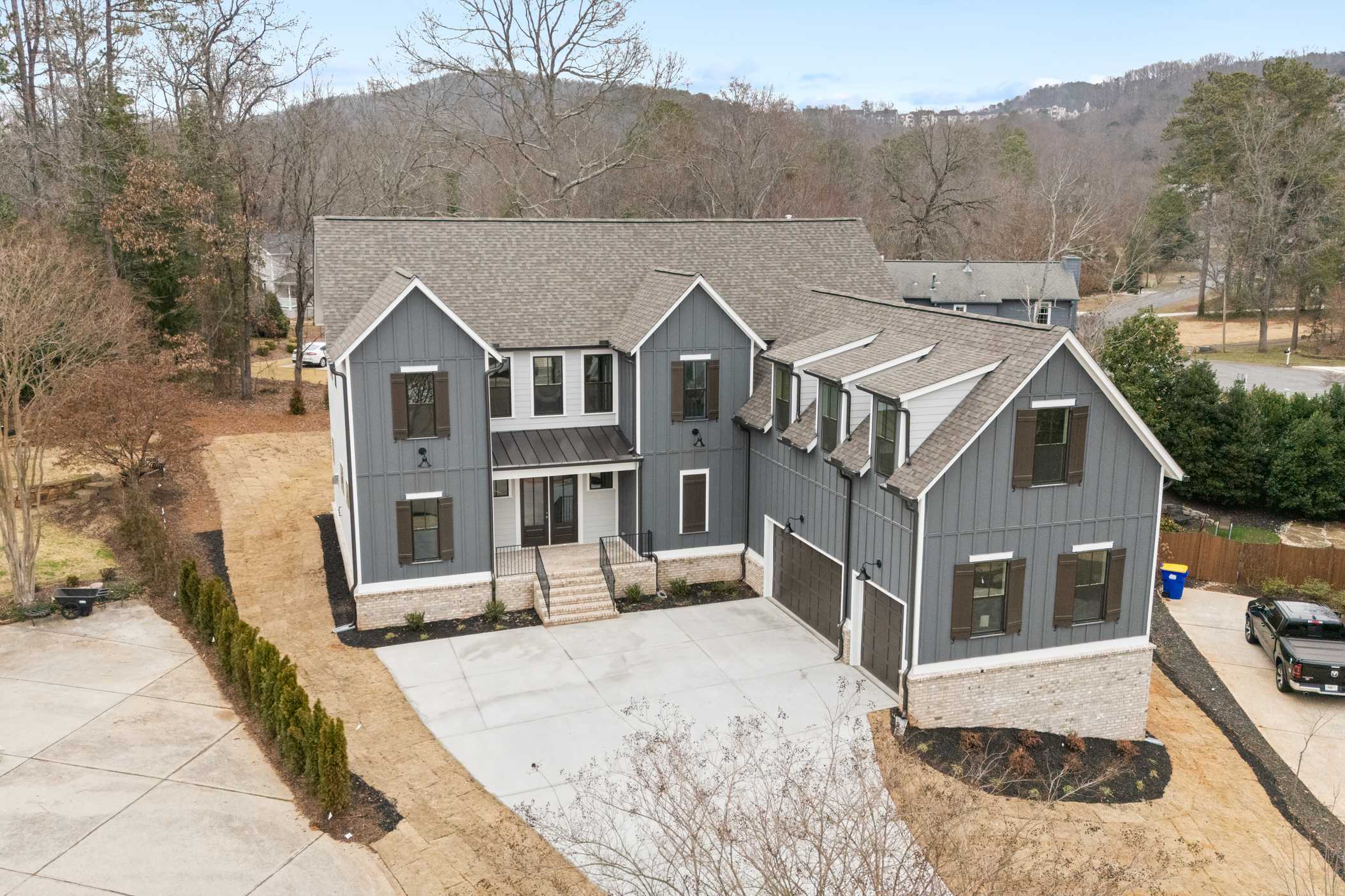 Modern gray shake siding home exterior at Tanglewood in East Cobb, Georgia with gabled roof, garage, and landscaped yard