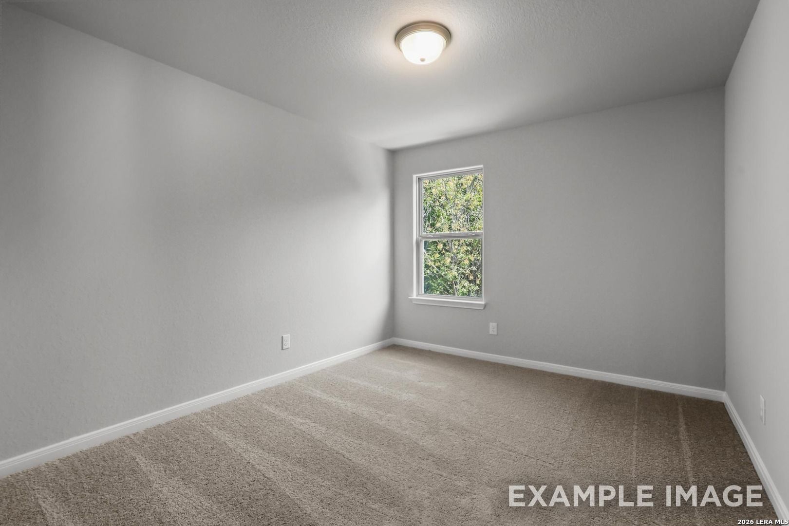 Bright, carpeted bedroom with neutral walls and a window in The Gillian A floor plan at Cedar Heights, San Antonio.