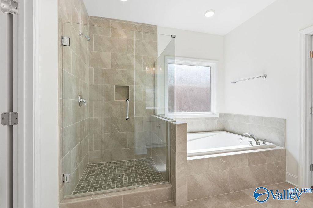 Modern master bathroom featuring glass-enclosed shower and freestanding tub in Davidson Homes The Montgomery, Hartselle, Alabama