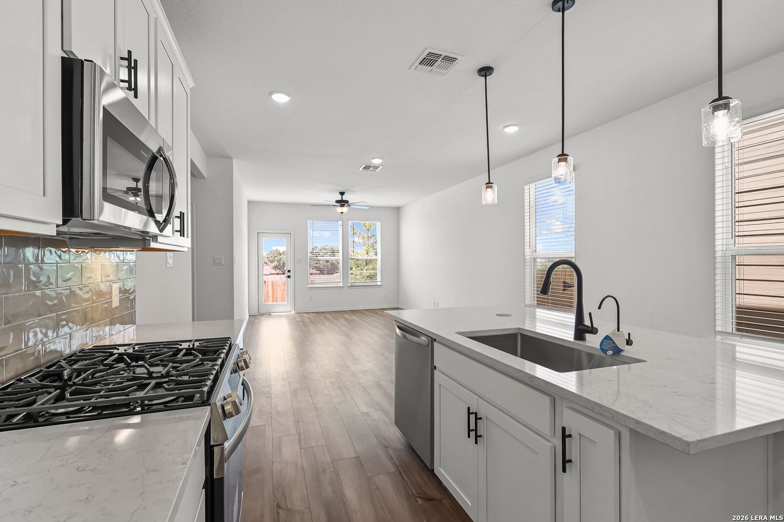 Modern kitchen with white cabinets and island in The Gillian C floor plan at Meadows at Oak Creek, San Antonio, Texas.