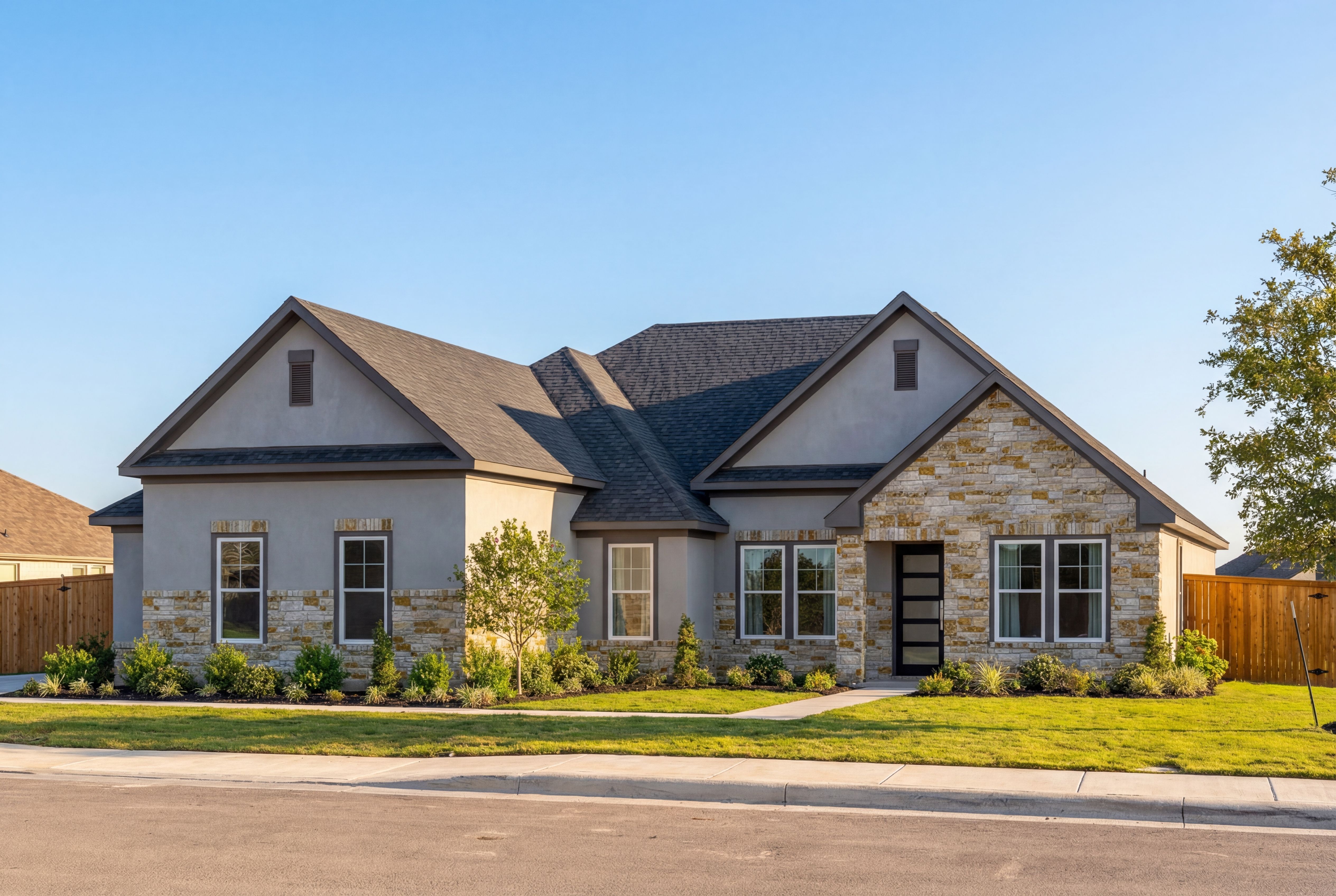 Modern single-story elevation of The Foster G showcasing stone accents, siding exterior, 3-car garage, and landscaped yard in Castroville TX