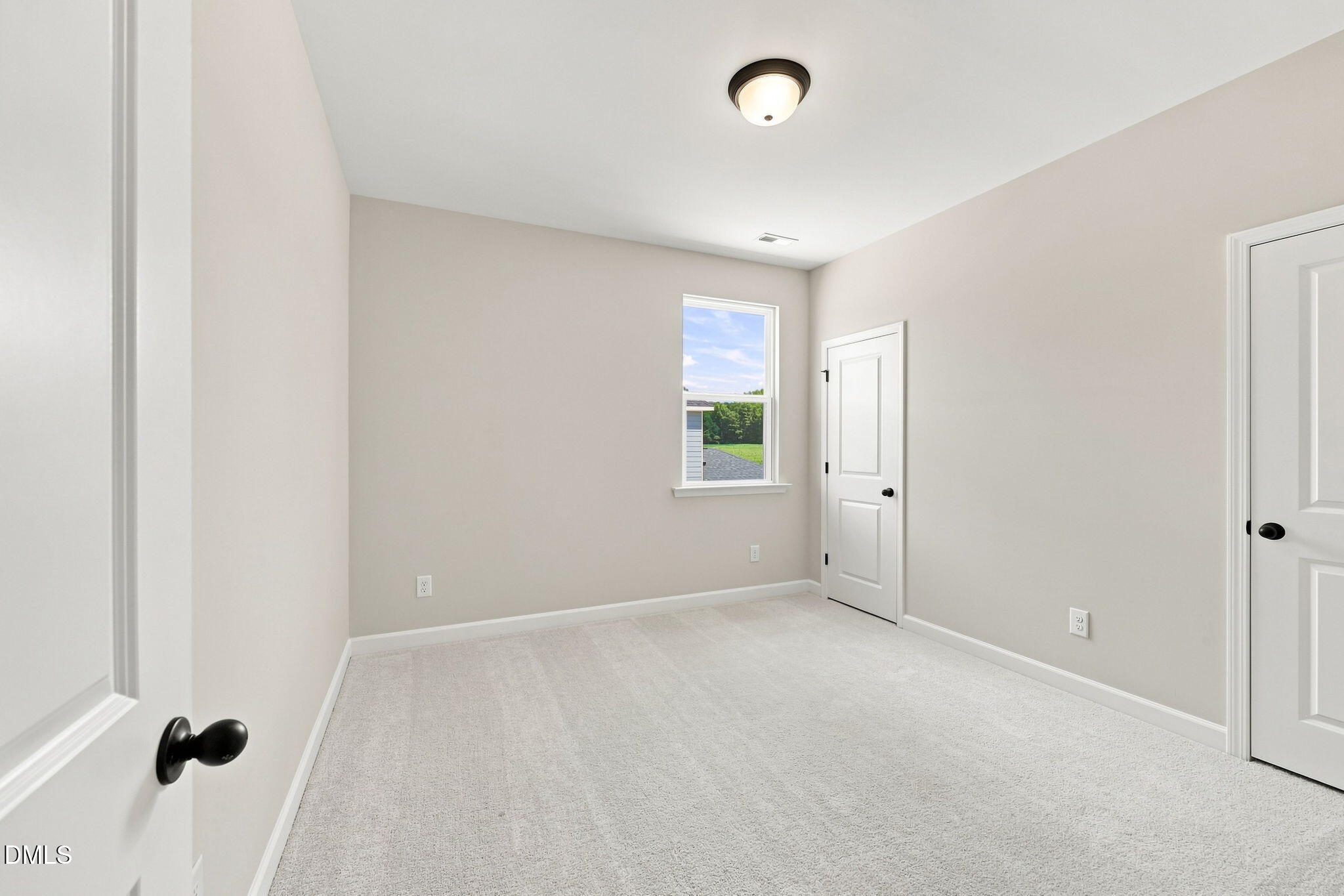 Spacious carpeted bedroom with neutral paint in The Harris C floor plan at Forestville Yard, Knightdale, North Carolina.