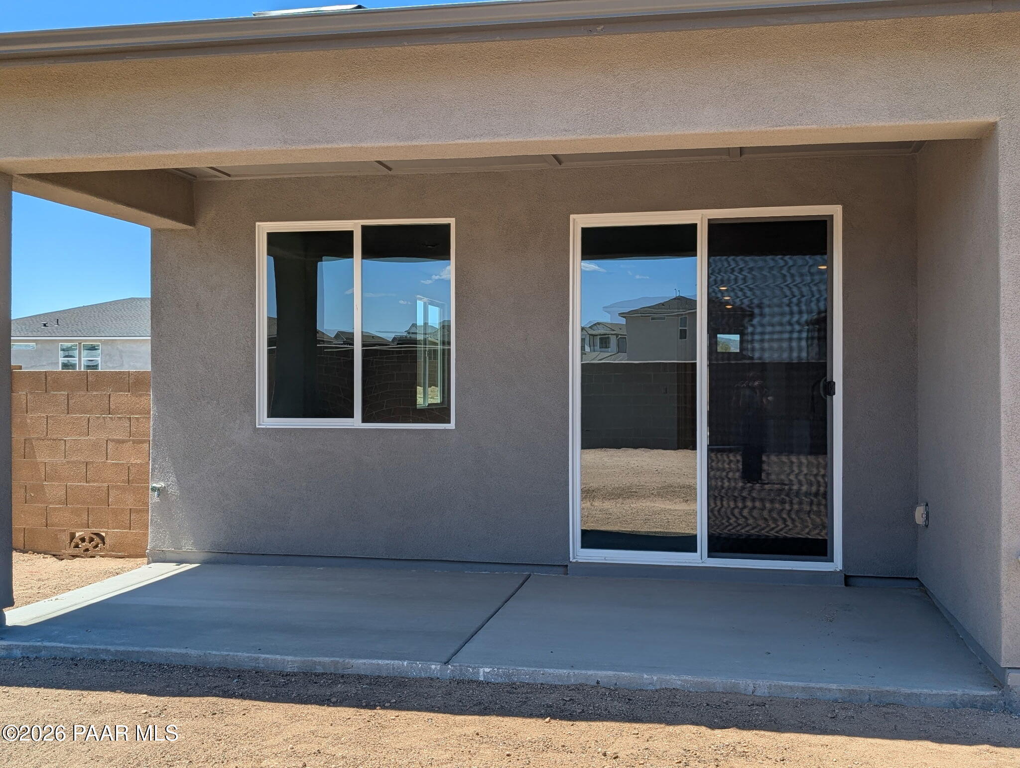 Covered concrete patio with sliding glass door in The Frontier II F home at South Ranch, Prescott, Arizona.