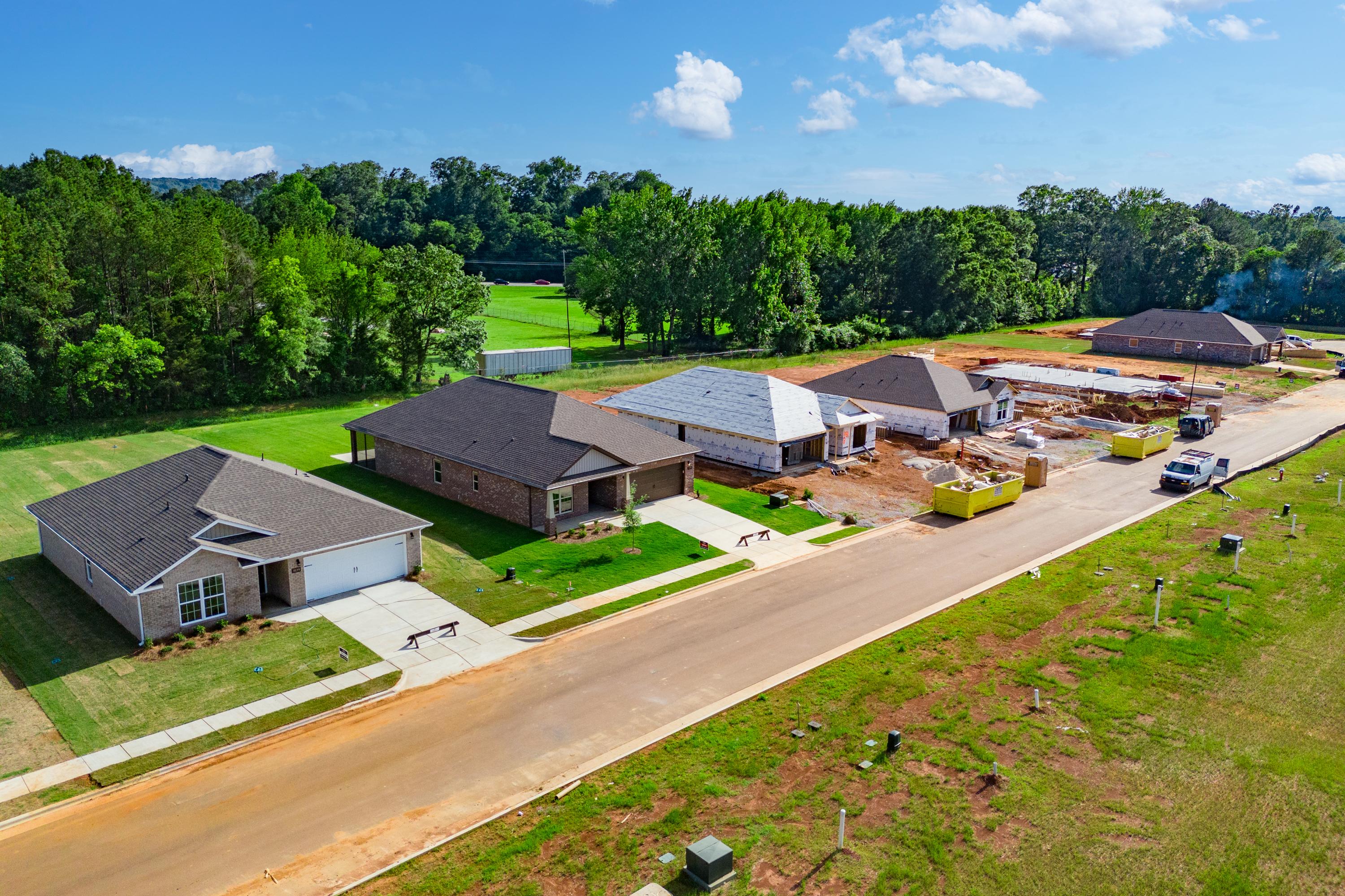 Aerial view of new homes under construction at Hollon Meadow in Decatur Alabama by Davidson Homes with green lawns and wooded backdrop