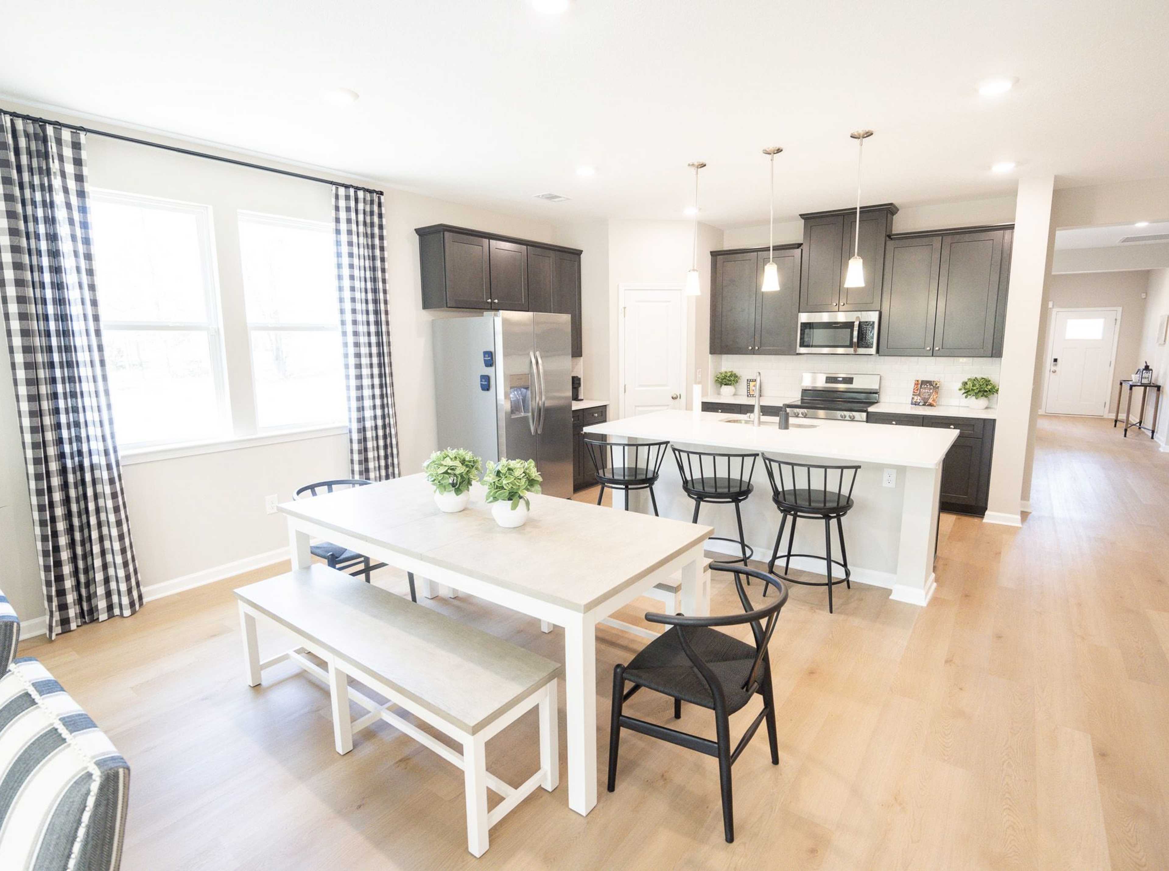 Spacious open-concept kitchen at Silver Oak in Cusseta Alabama with dark cabinets white island farmhouse table and hardwood floors