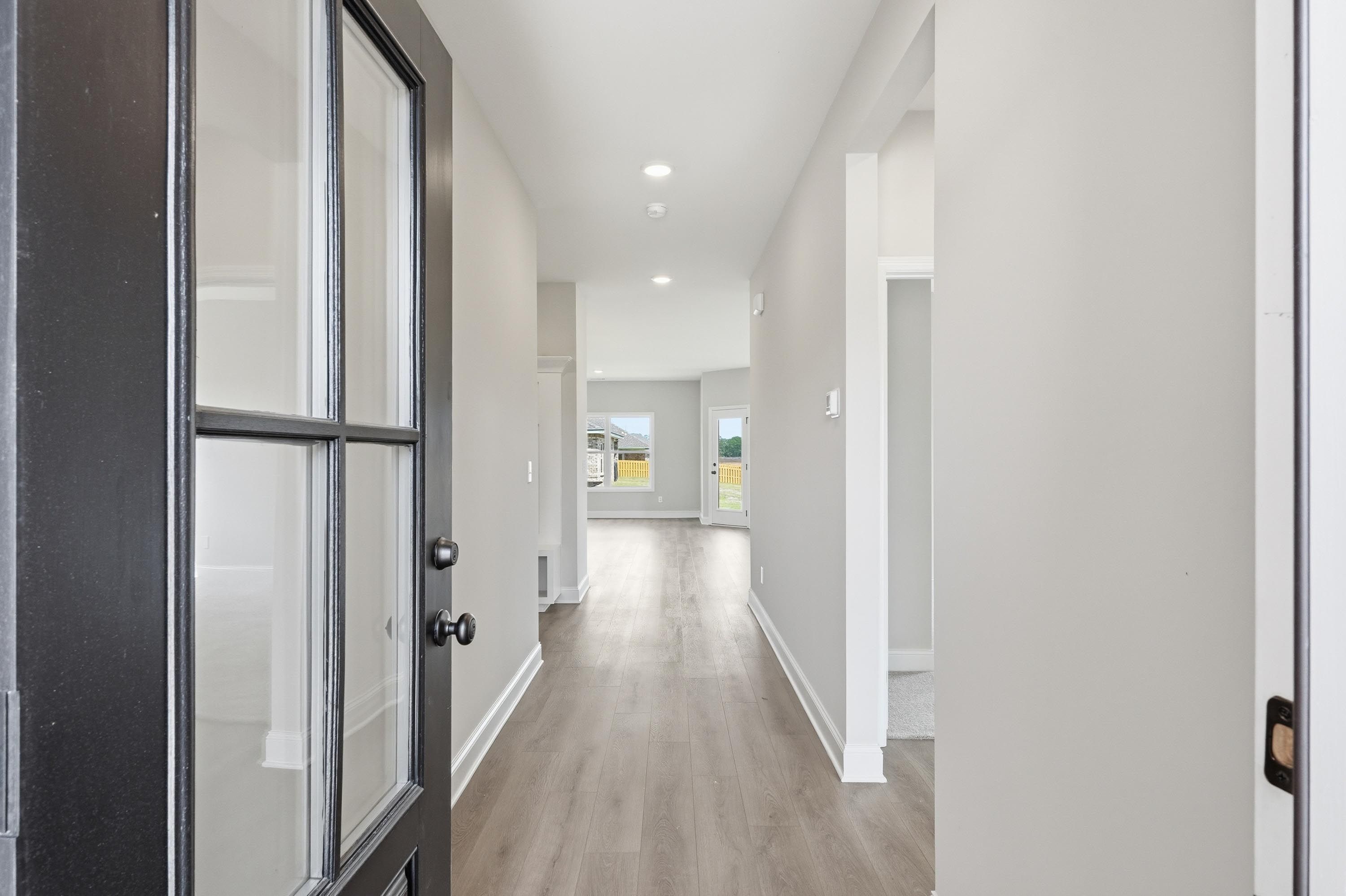 Bright, open entryway of The Glen A floor plan by Davidson Homes in Josephine, Texas featuring modern wood-look flooring.