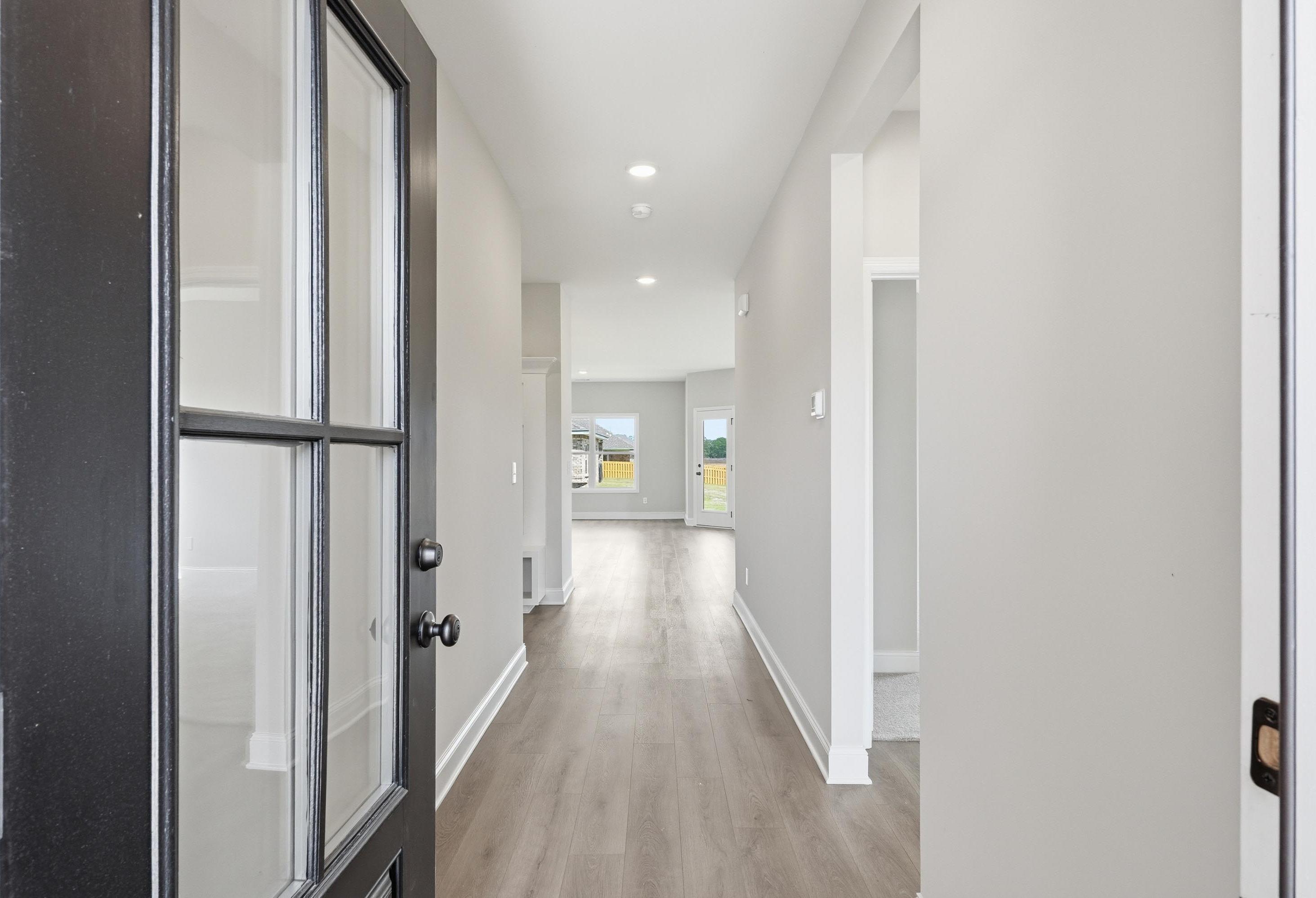 Bright, open entryway of The Glen A floor plan by Davidson Homes in Josephine, Texas featuring modern wood-look flooring.