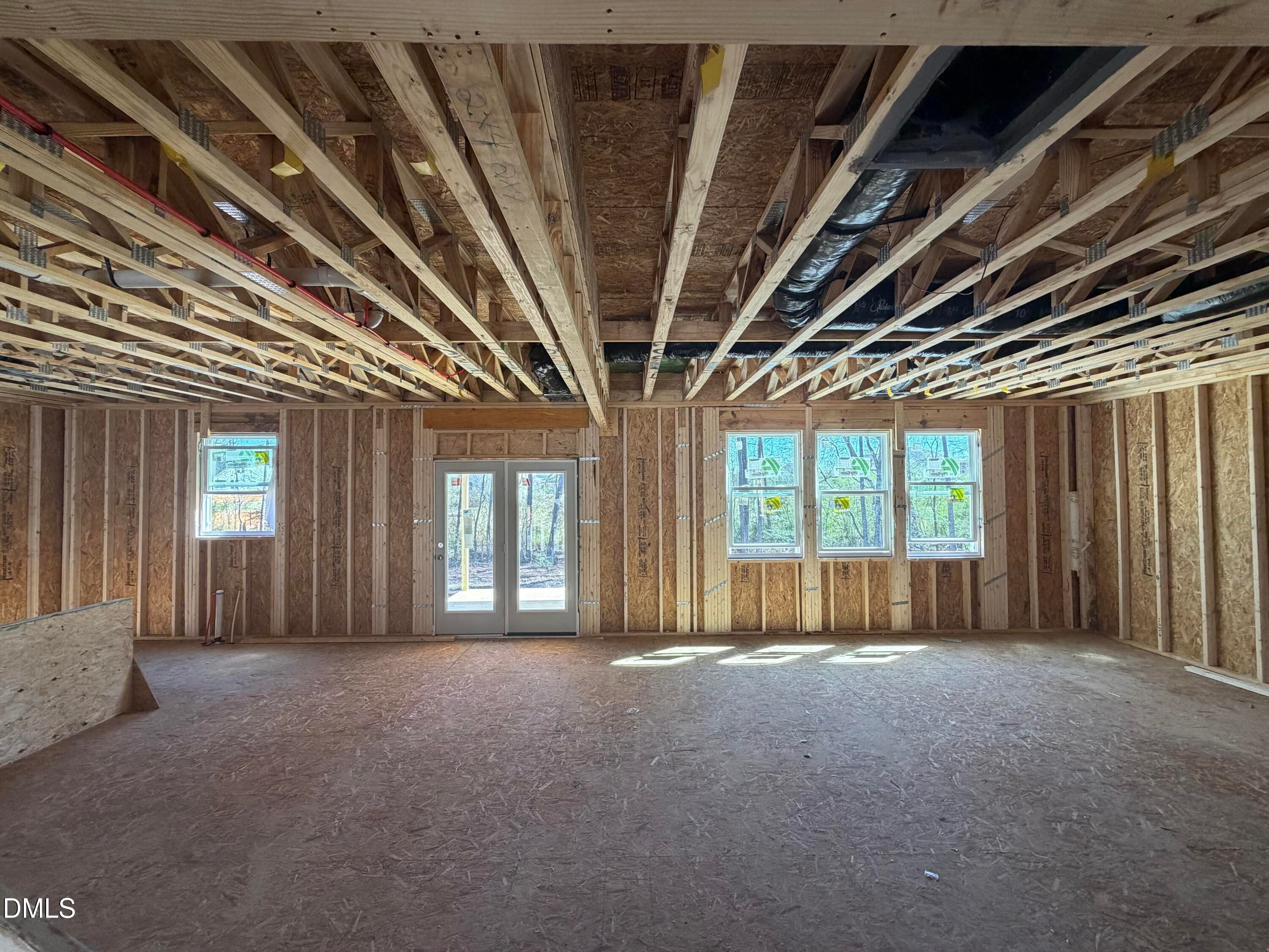 Framed open living space with large windows, exposed beams, and HVAC ducts in 5-bedroom Hickory II B home, Lillington, NC