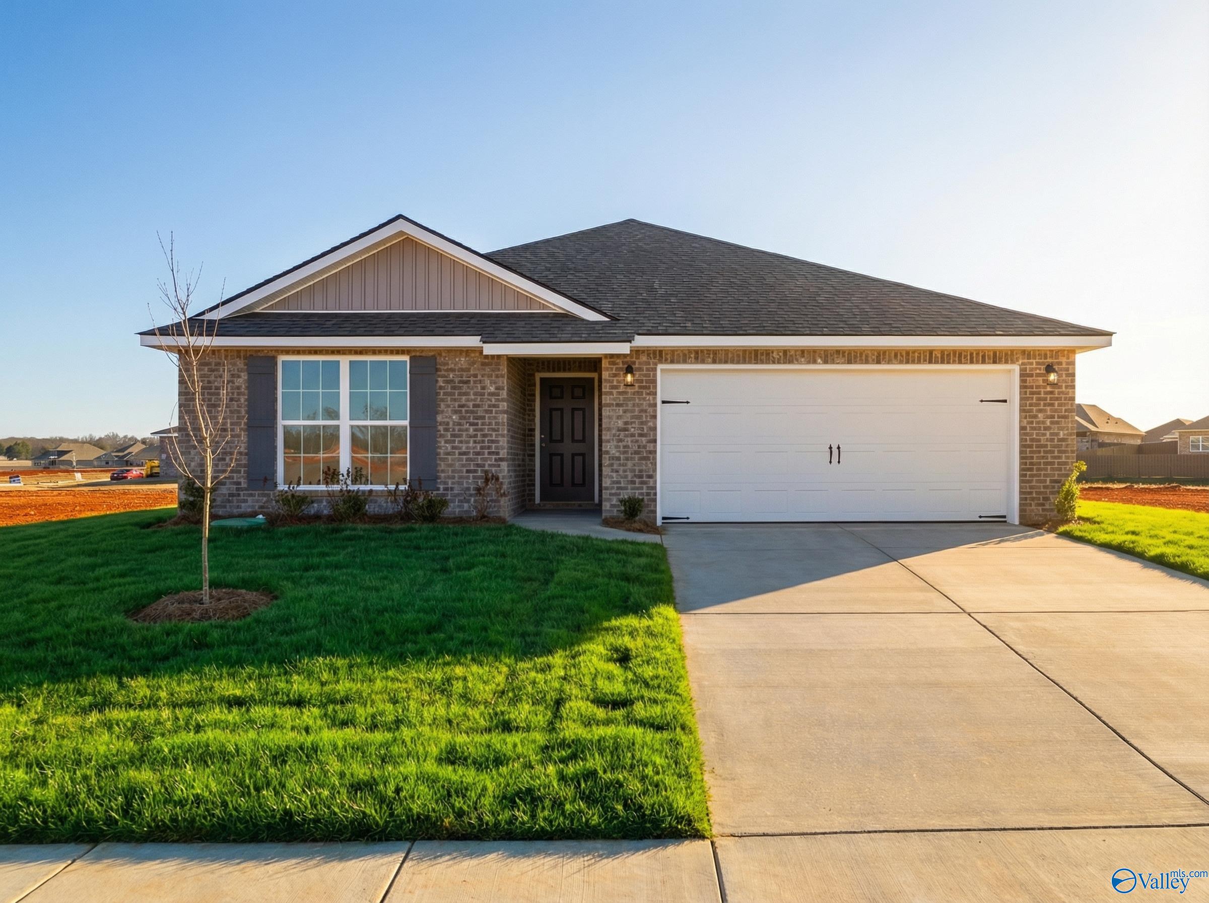 Modern 1-story brick home with 2-car garage, large windows, and green lawn in Heritage Lakes, New Market, Alabama by Davidson Homes The Franklin