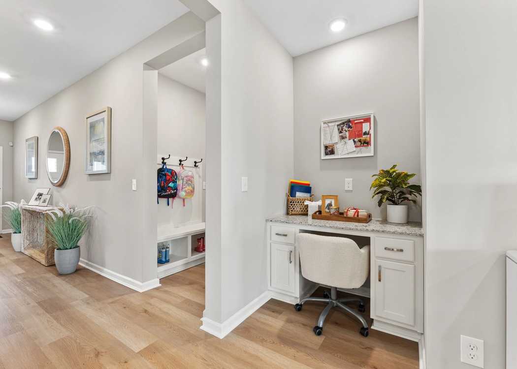 Built-in drop zone with backpack hooks and a small desk area for organizing school essentials in a modern home entryway.