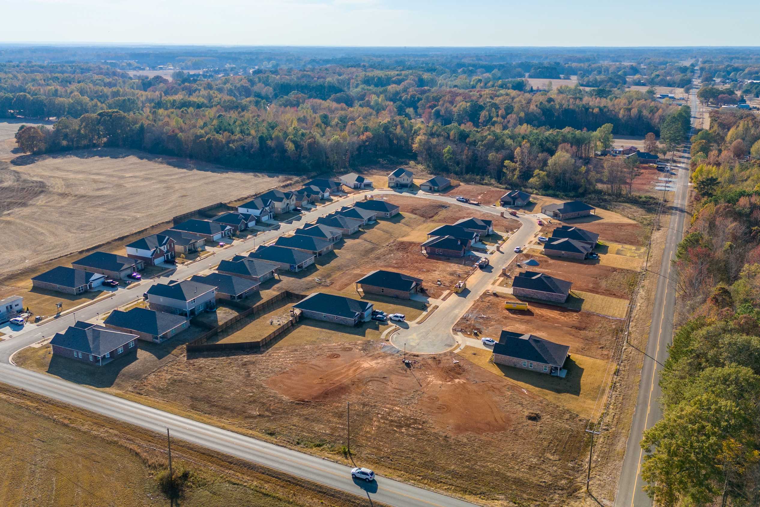 Aerial view of new Davidson Homes in Mallard Landing, Athens Alabama, with clustered single-family houses amid fields and fall woods