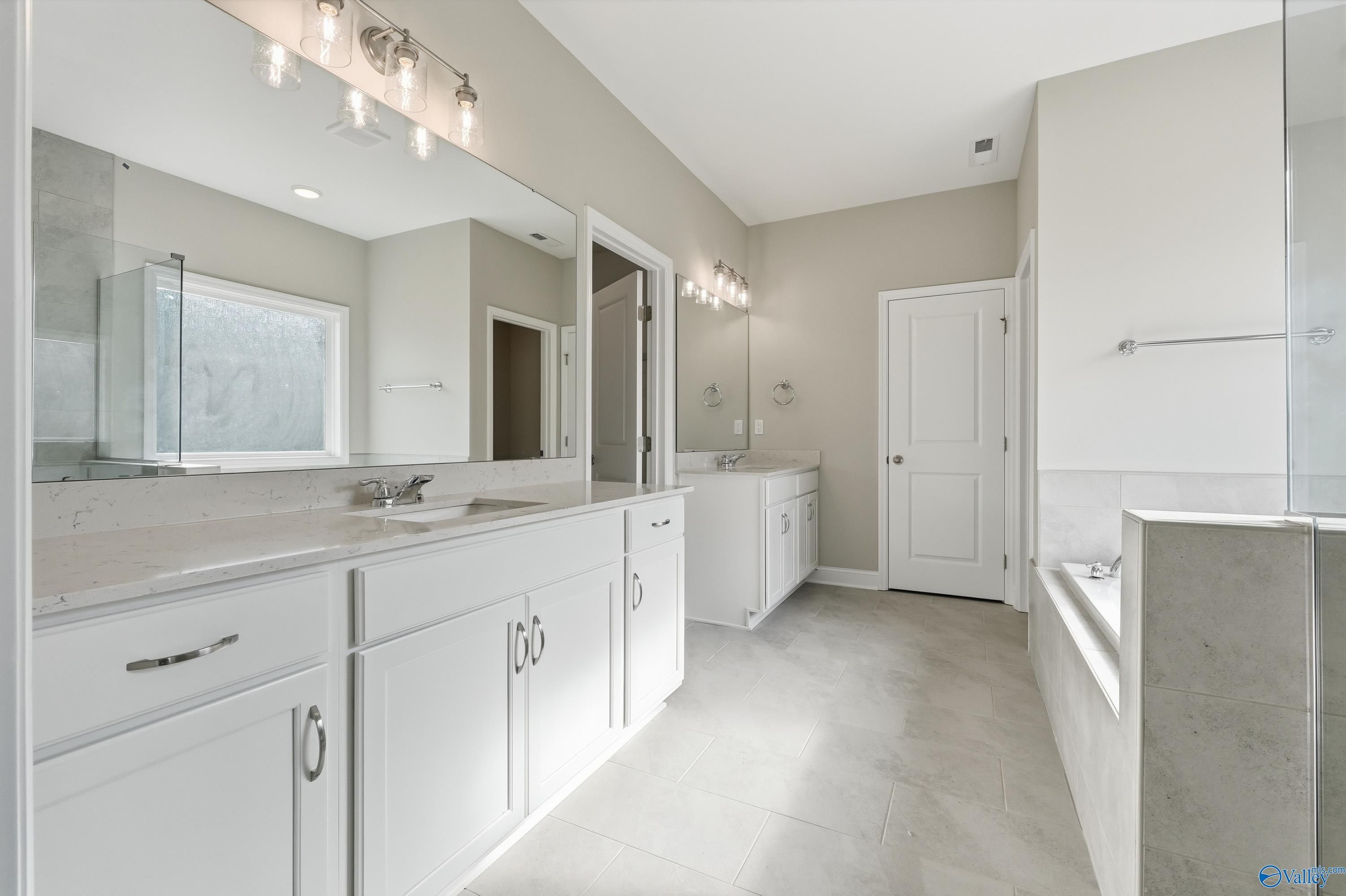 Elegant master bathroom with double vanity, freestanding tub, and tiled flooring in Davidson Homes The Lanier, Meridianville, AL