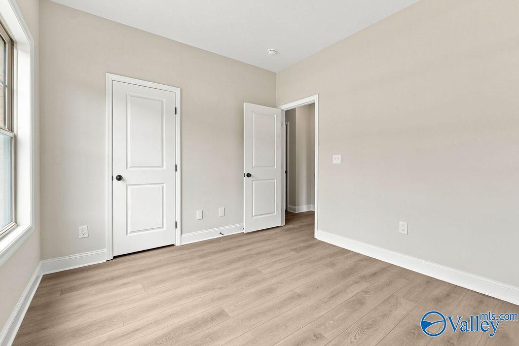 Bright secondary bedroom with wood-look flooring in The Camilla B floor plan at The Retreat at Cain Park, Hartselle, AL.